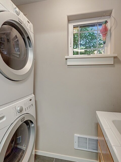  The laundry room in the garage has full size stacked units and a laundry sink. 