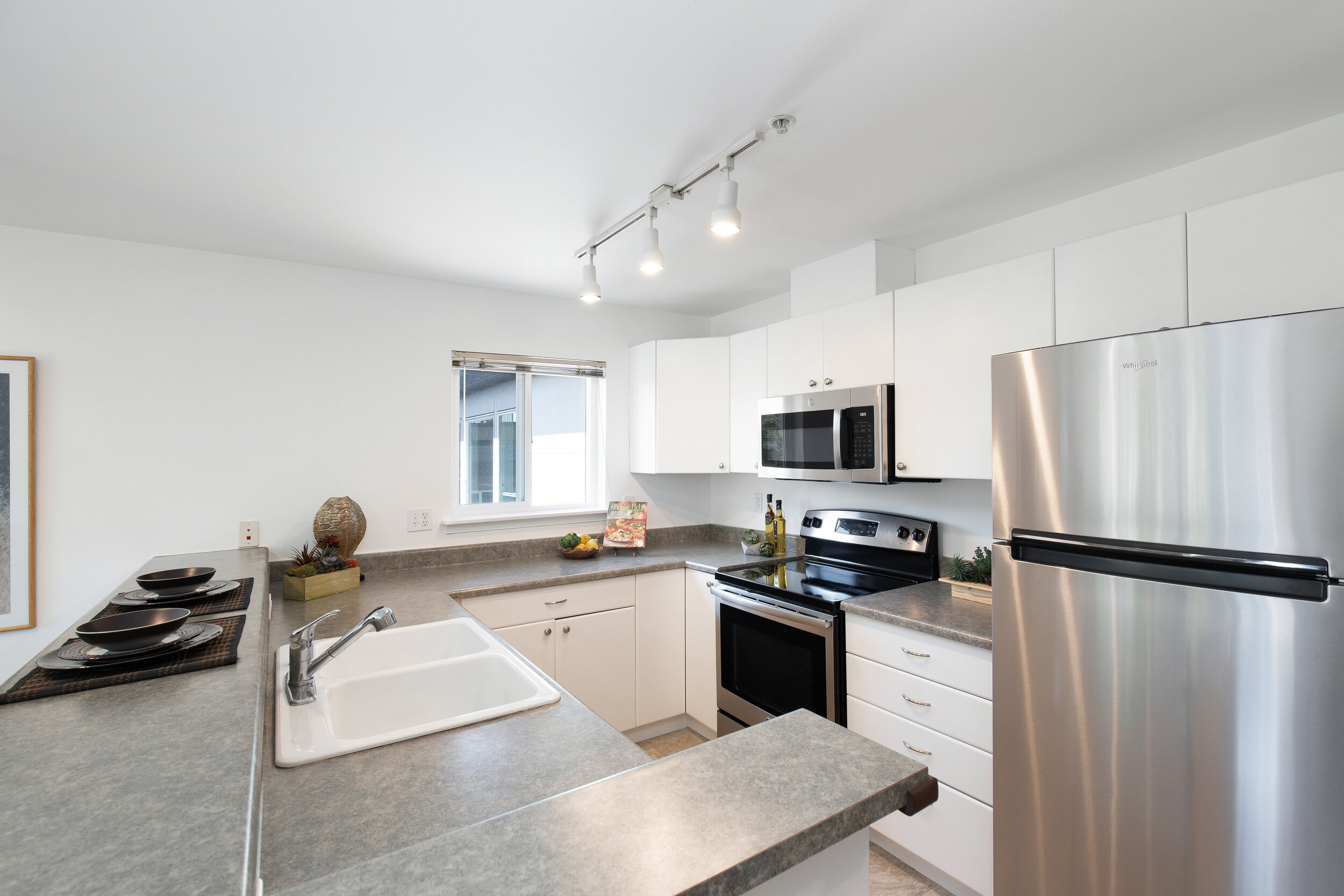  Abundant counter space and cabinetry and a new stainless steel refrigerator and microwave. 
