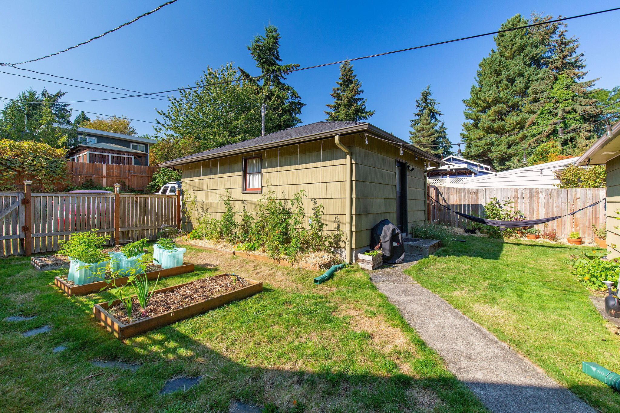  A detached garage off the alley with great storage for gardening tools and outdoor gear. There is also currently a chicken coop around the corner from the hammock that can be used or easily transformed into more garden or storage space. 