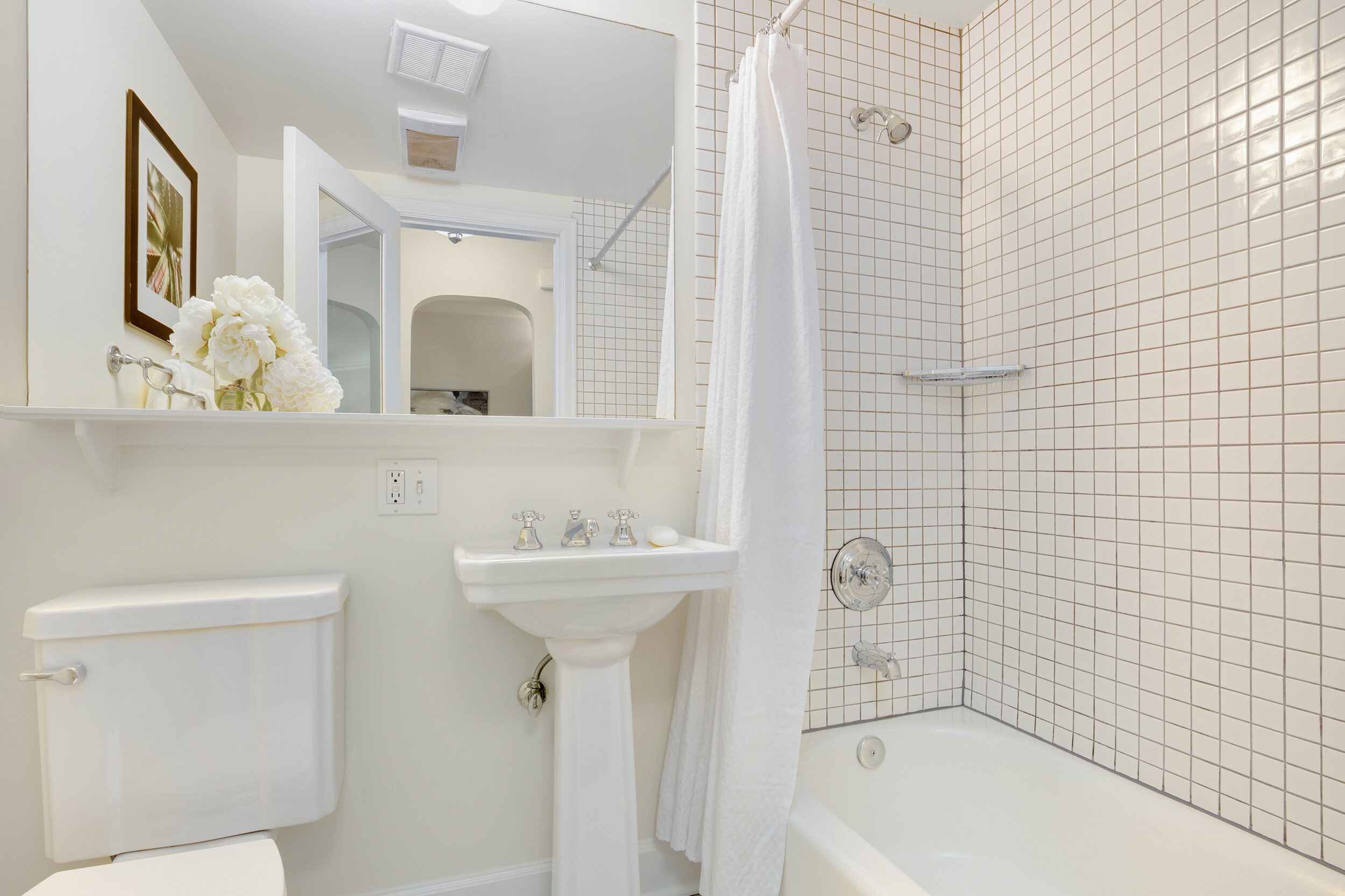  image description: interior of all white bathroom with shower and bathtub combo 