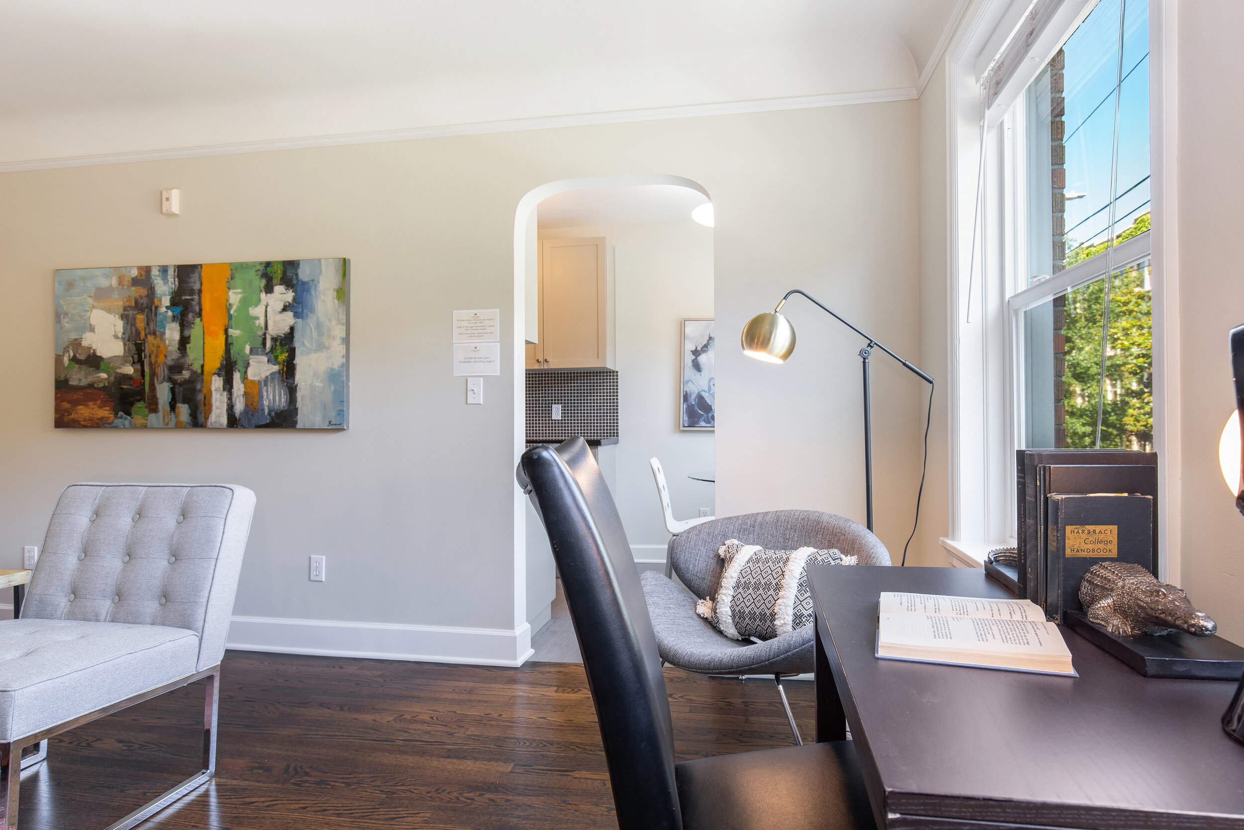  image description: interior of living room with windows, couch, desk and chair 