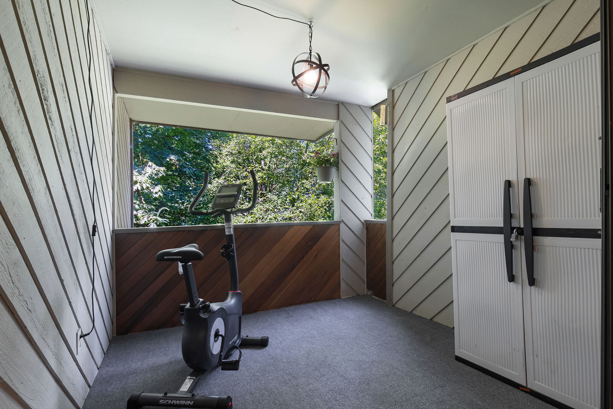  interior of exercise/storage room with exercise boke and large window 