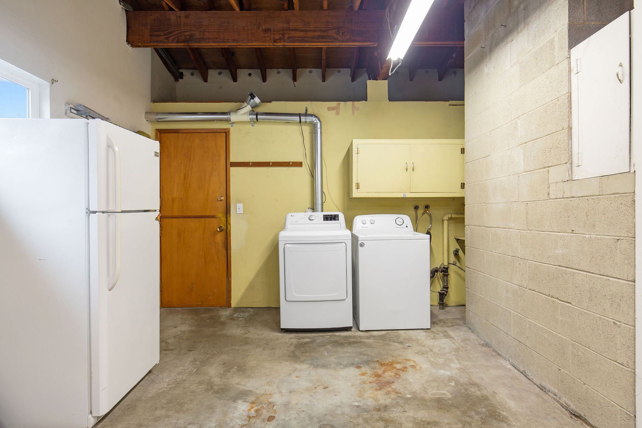  image description: interior of lower floor with fridge, and washer and dryer 