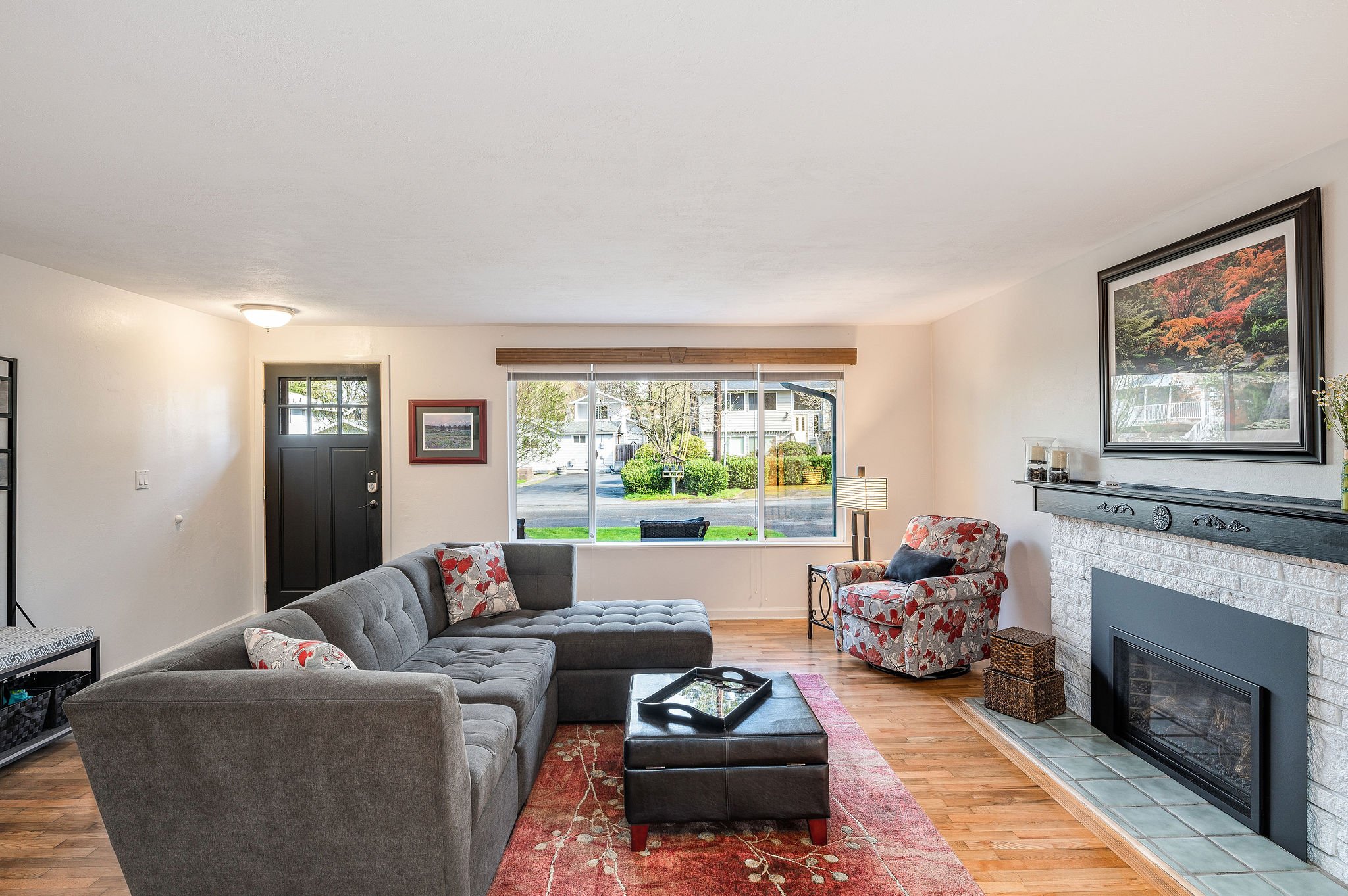 Enter into the bright and open formal living room with a gas fireplace and hardwood floors.