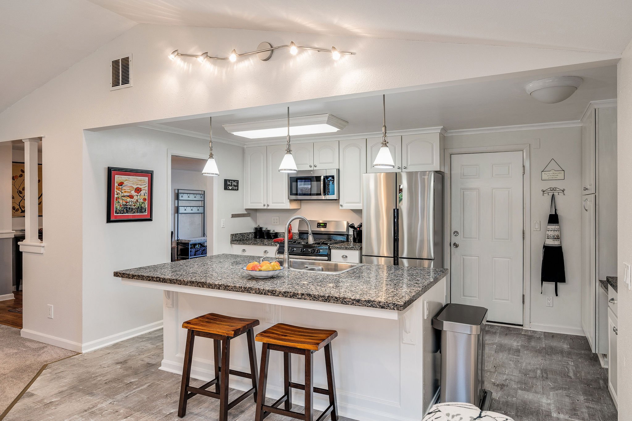 The door to the right of the refrigerator leads to the one-car garage with laundry and built-in storage.