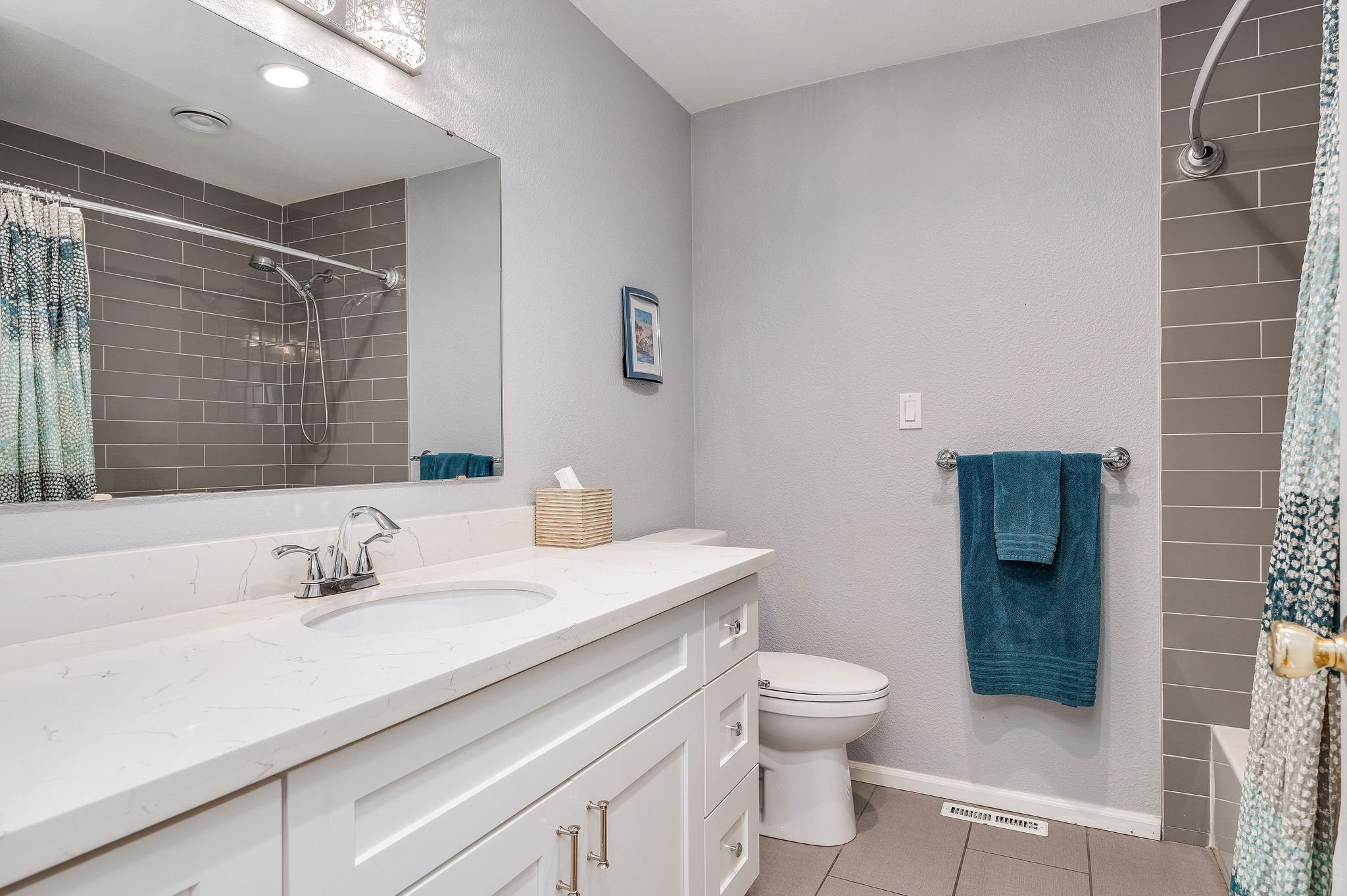 The large, updated hall bath with a tub and linen-closet.