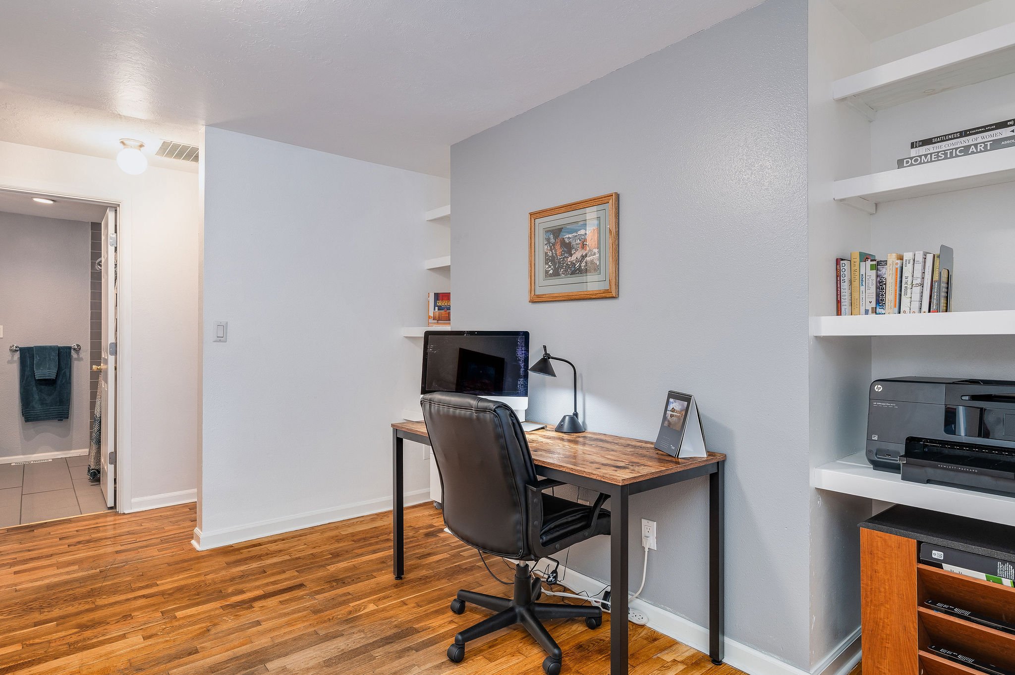  image description: interior of office with desk, chair and shelving 