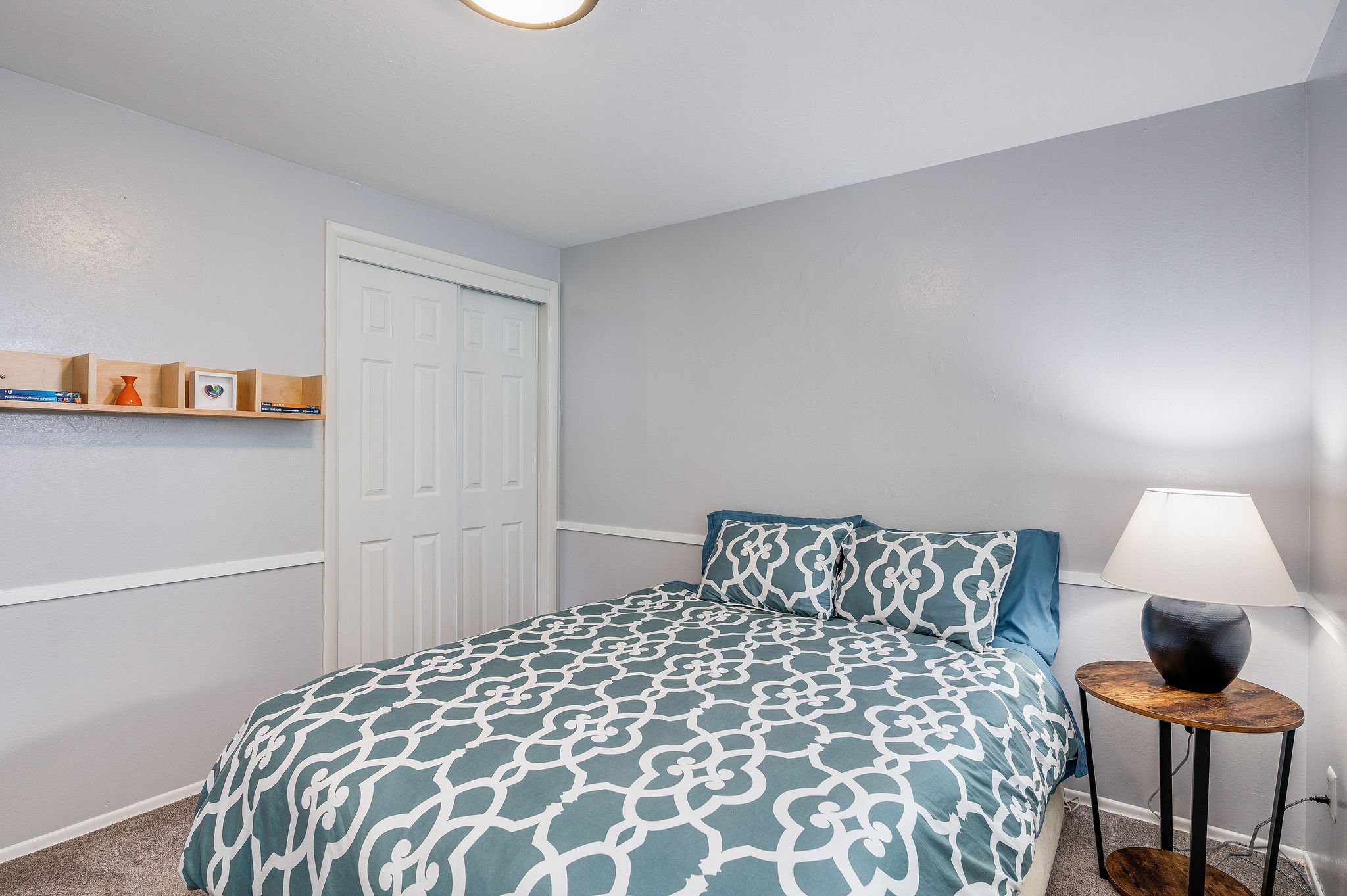  image description: interior of bedroom with king bed, closet and window 