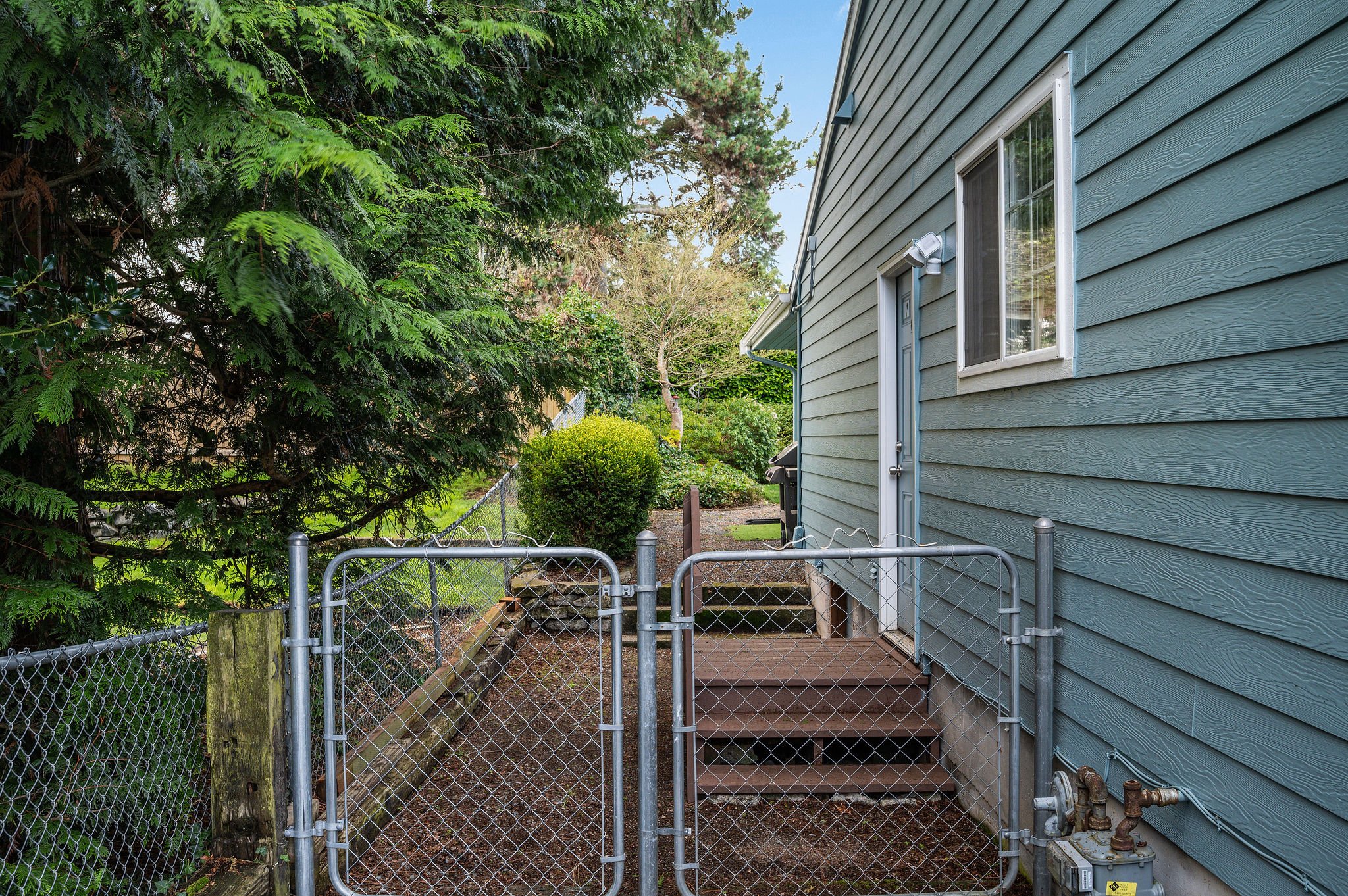  image description: view of walkway on the side of the house with gate 