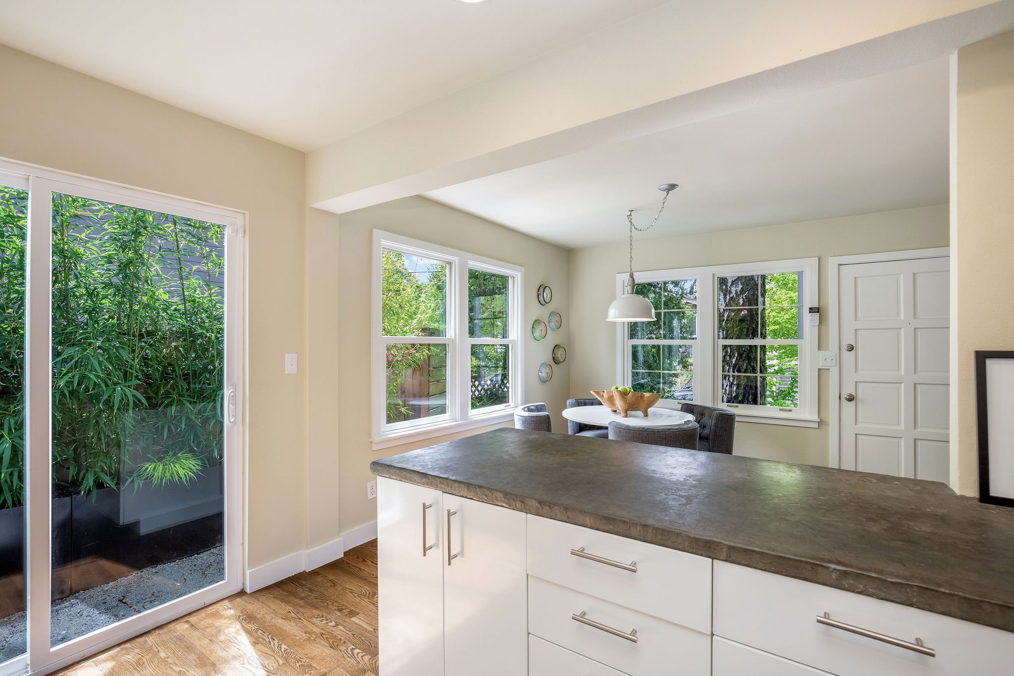  image description: interior kitchen with connected island, hardwoods, brown countertops and sliding glass door 