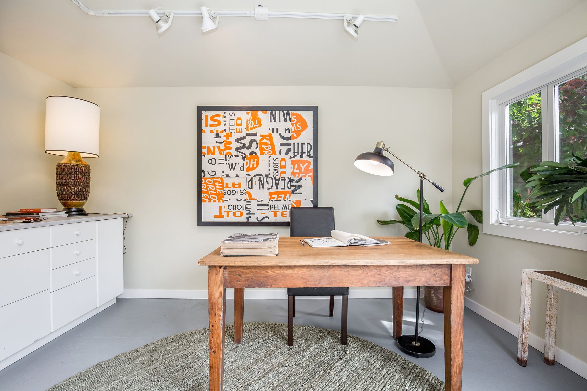  image description: interior of office with long dresser, arm chair, desk and chair, and carpet 