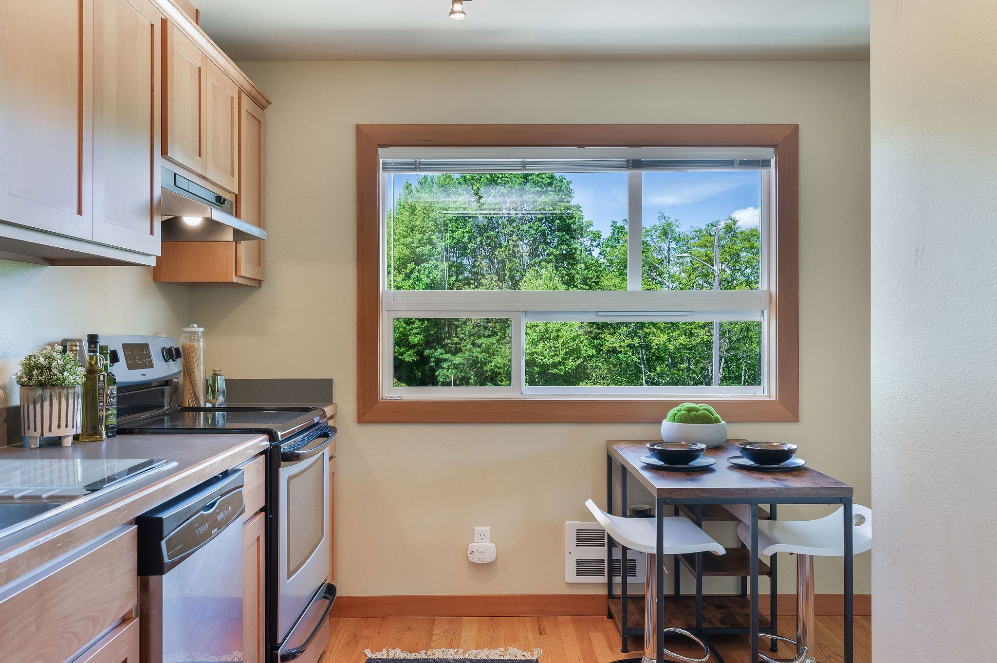  Image description: interior of studio kitchen with window and small dining table 