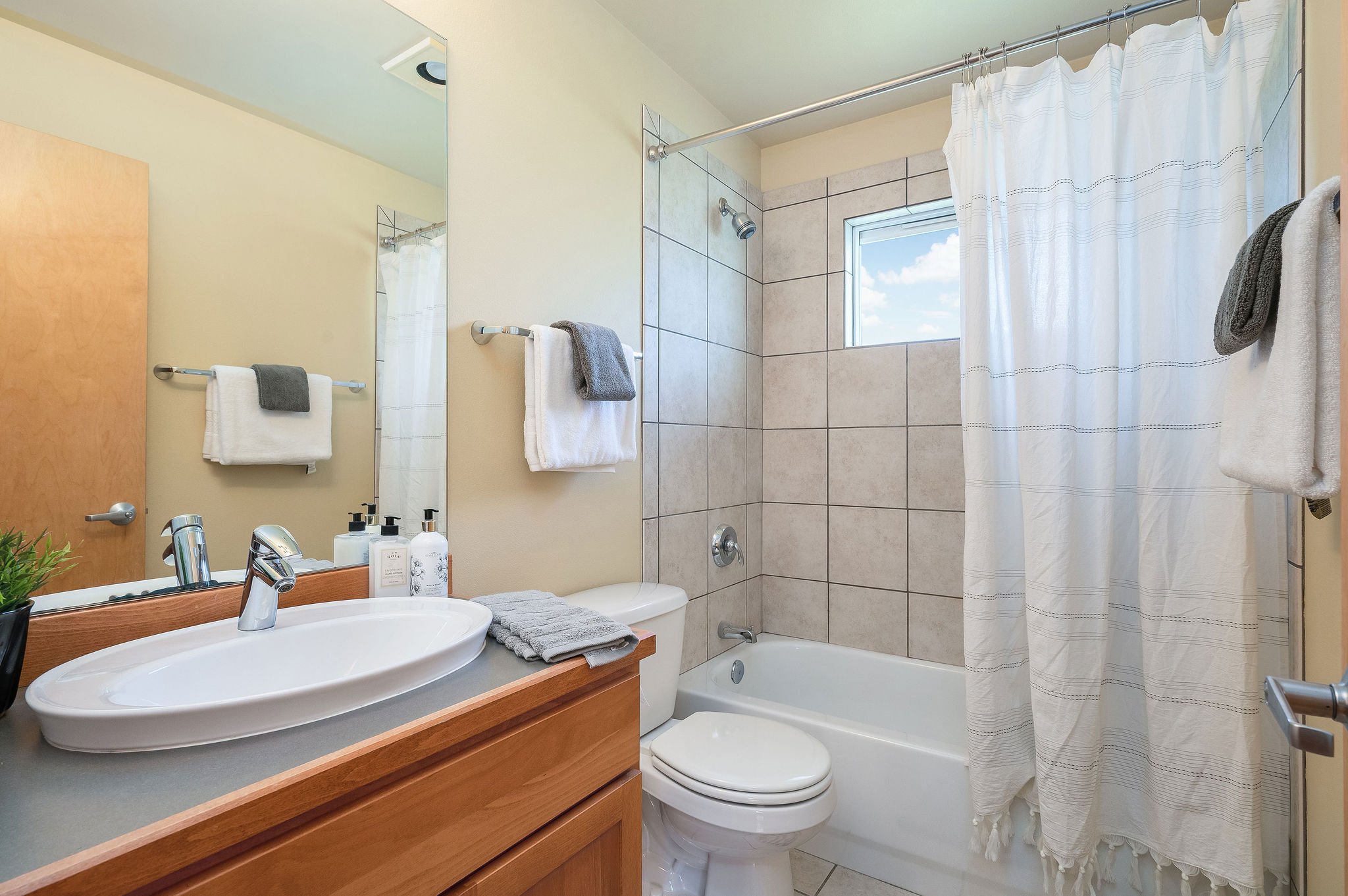  Image description: interior of bathroom with bathtub and shower combo and small window 