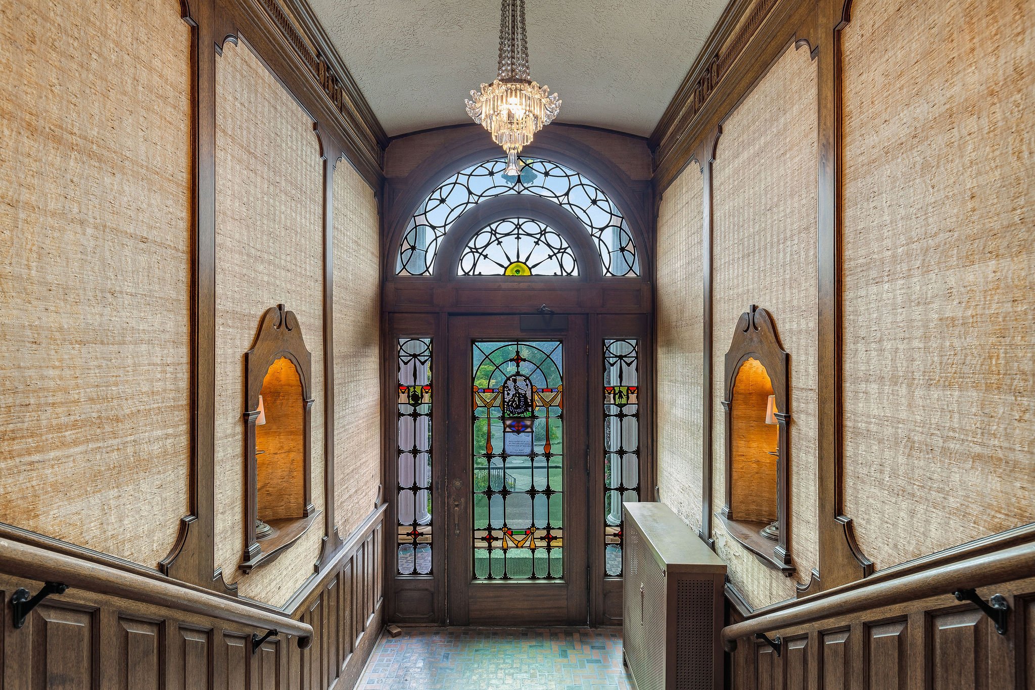 Mahogany woodwork, original chandeliers and stained glass detail in the lobby entrance. 