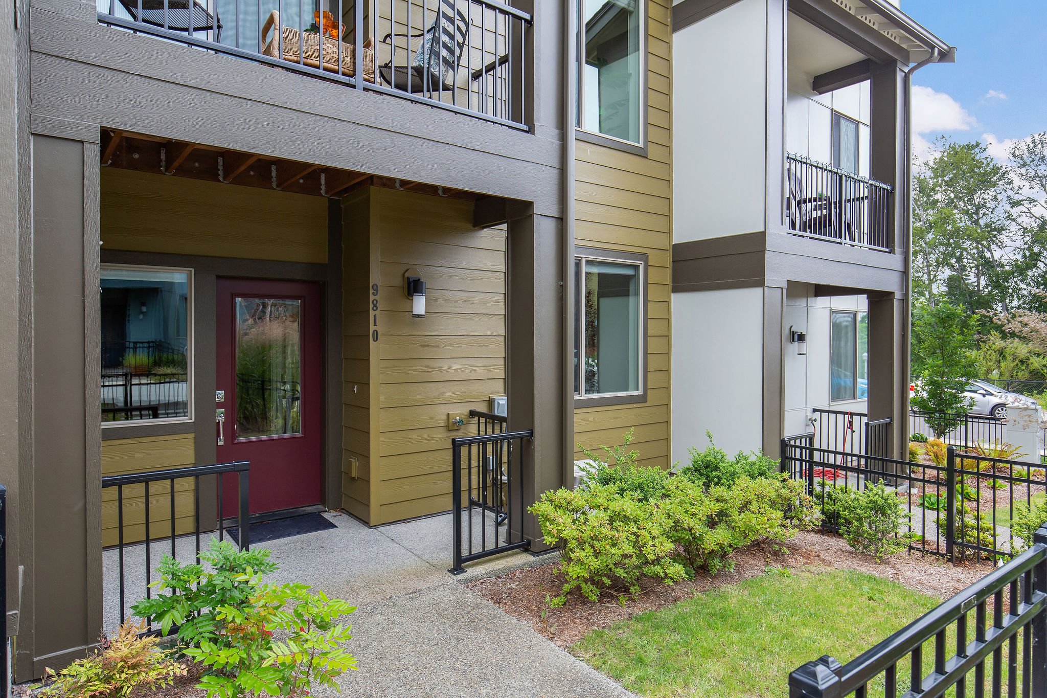  image description: exterior of townhouse with balcony and fence 