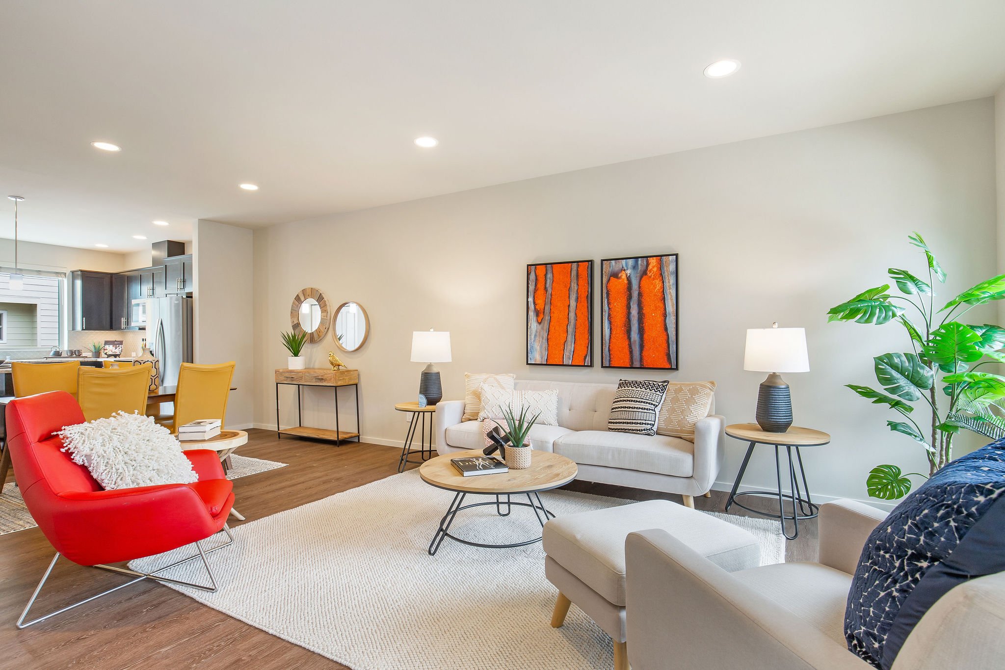  image description: interior of living room with hardwoods, large window, couch, rug and chairs 