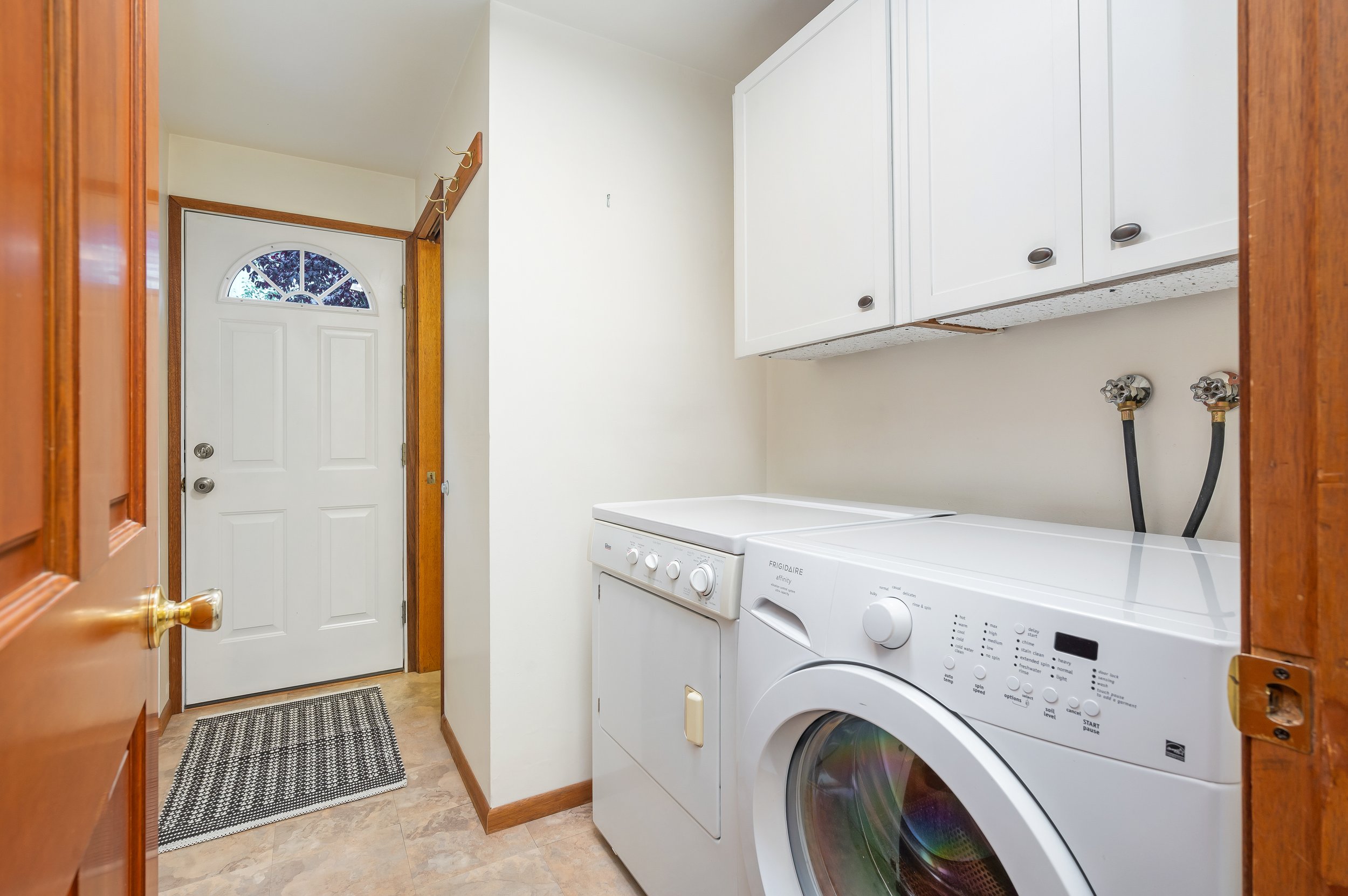  interior of laundry room with washer and dryer and door to yard 