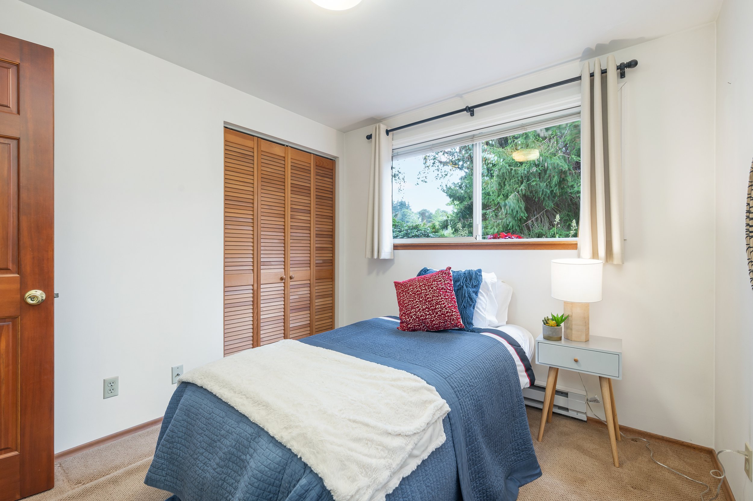  interior of bedroom with large window, carpet, closet, and full bed 