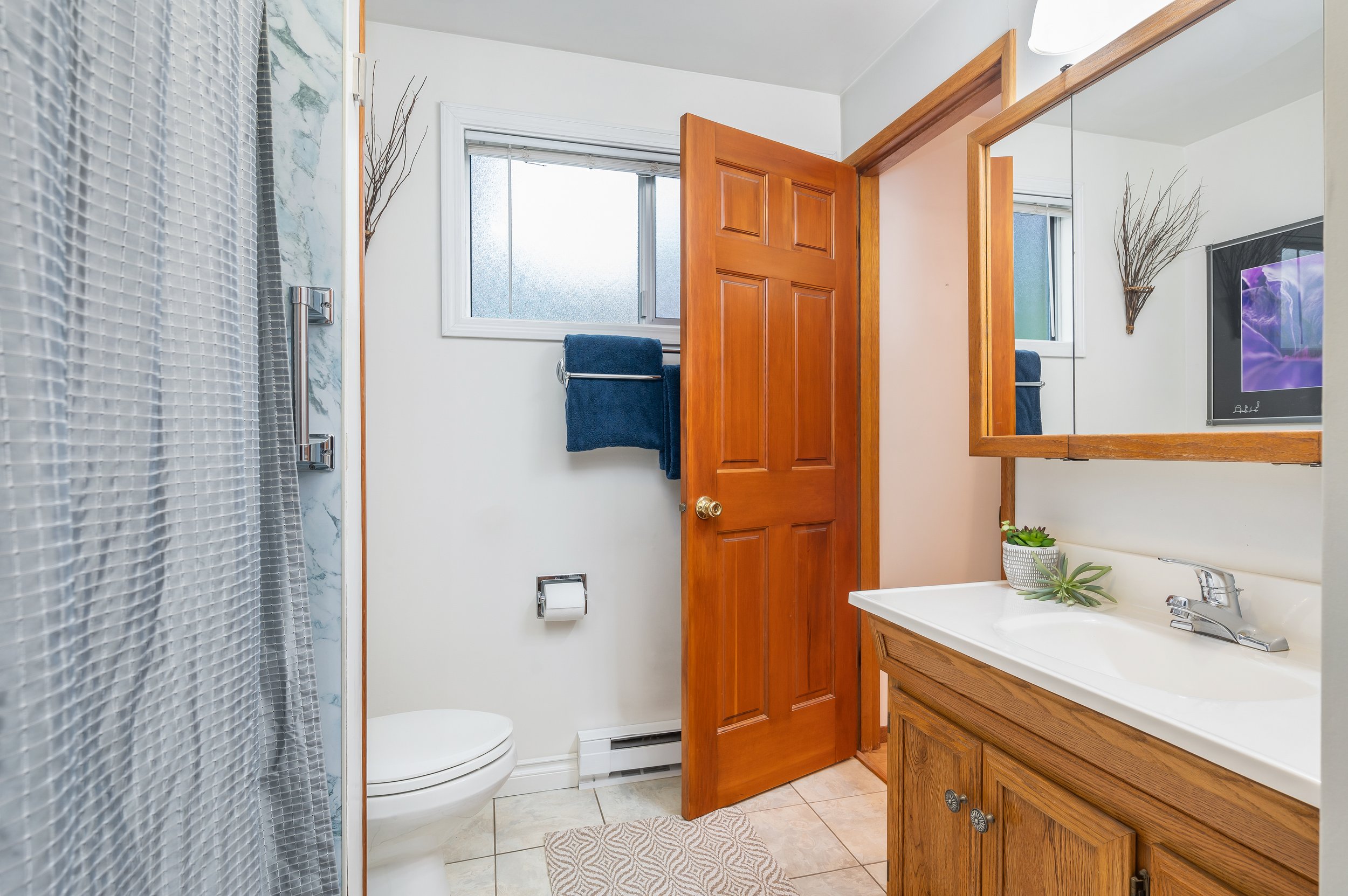  interior of bathroom with tile floor, shower and window 