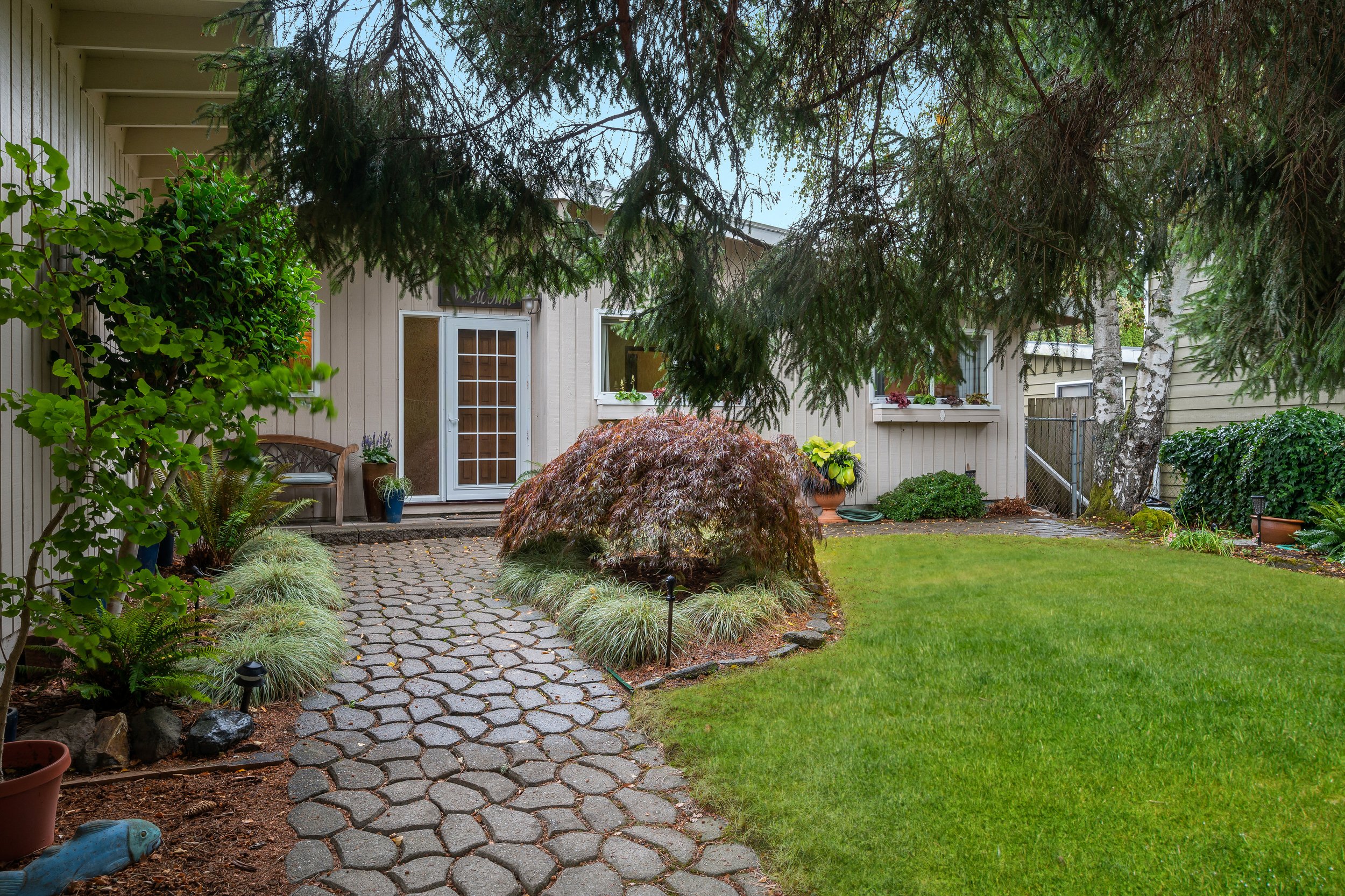  exterior of one story house with stone pathway and glass front door 