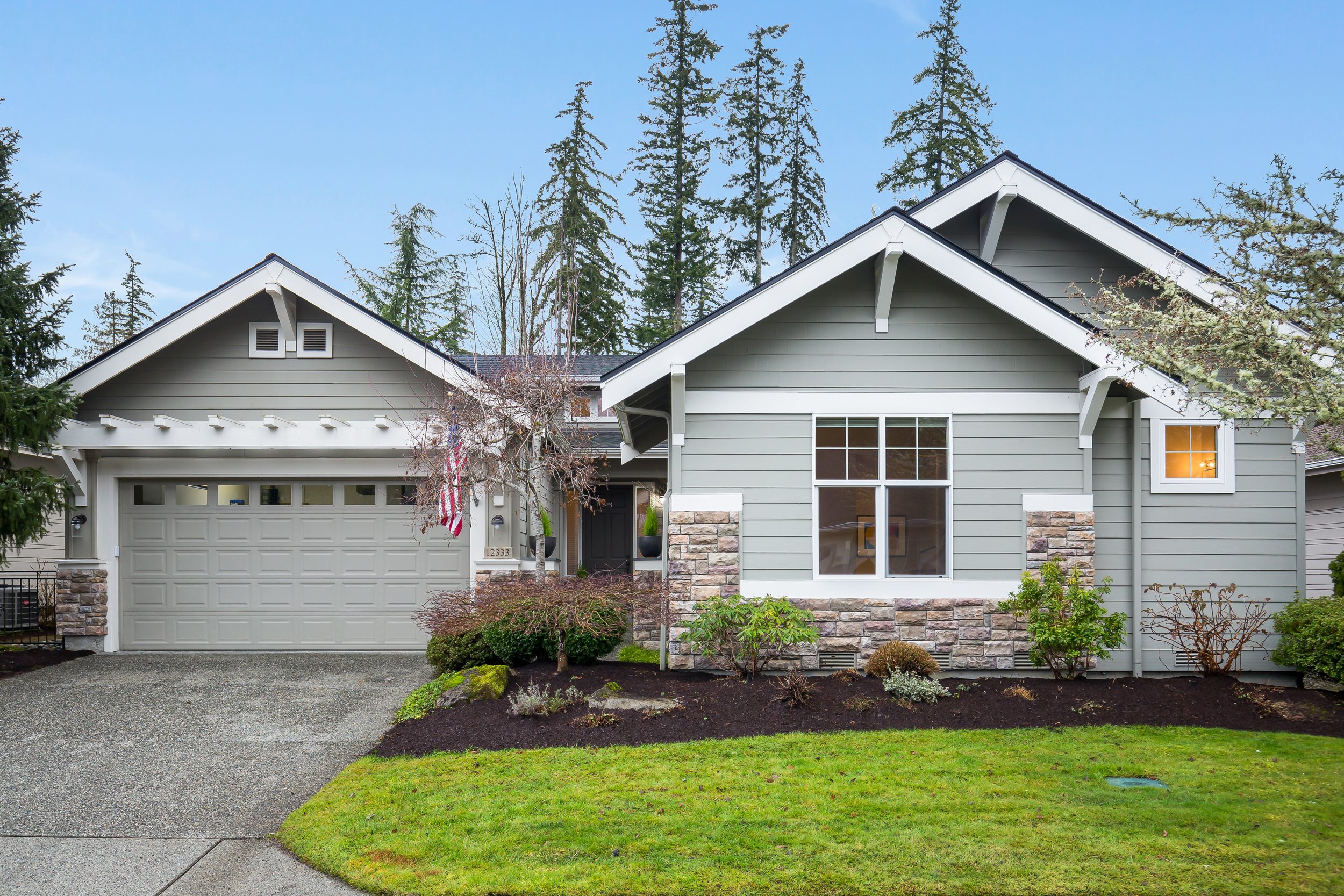  exterior of grey one story house with garage and yard 