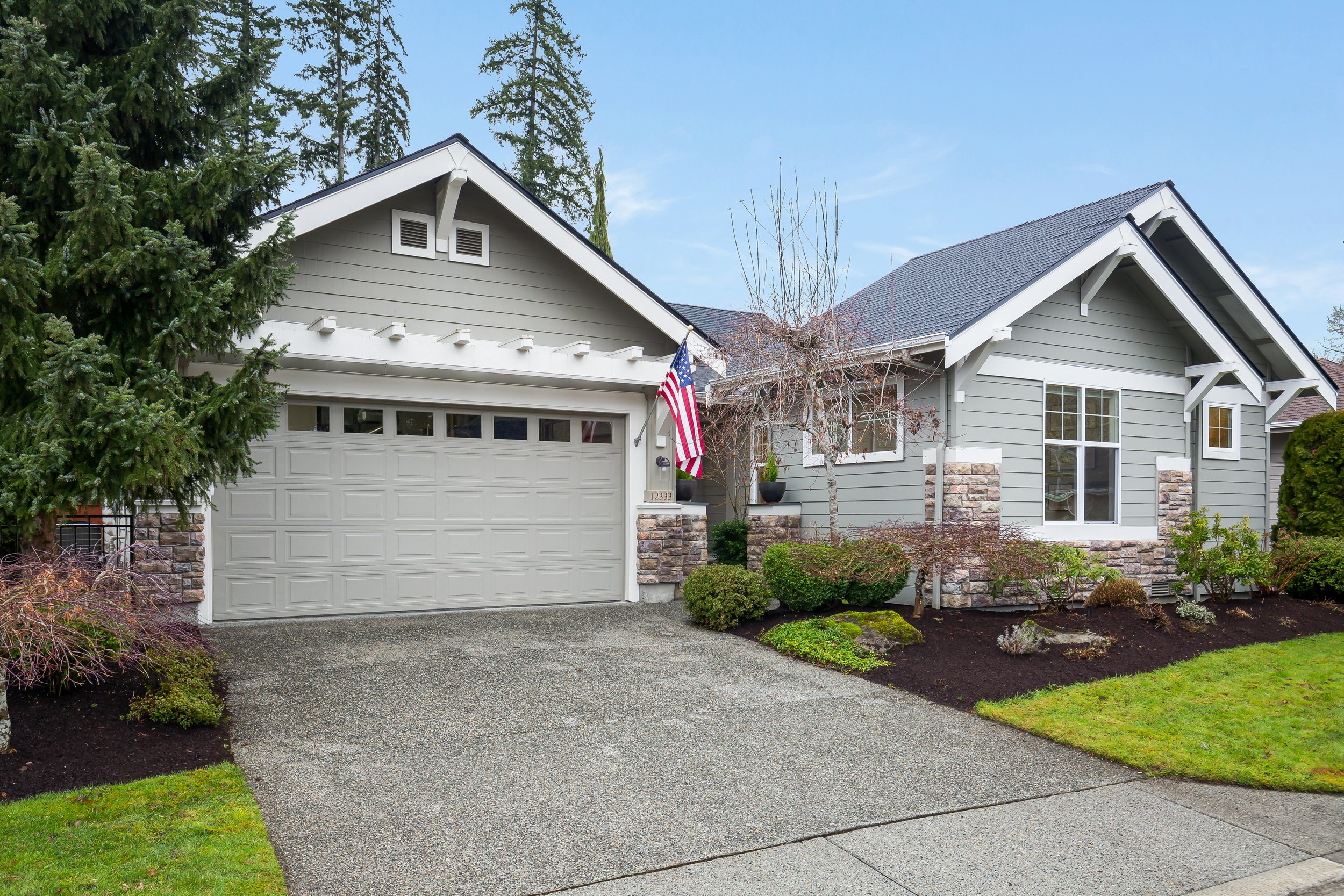  exterior of grey one story house with garage and yard 