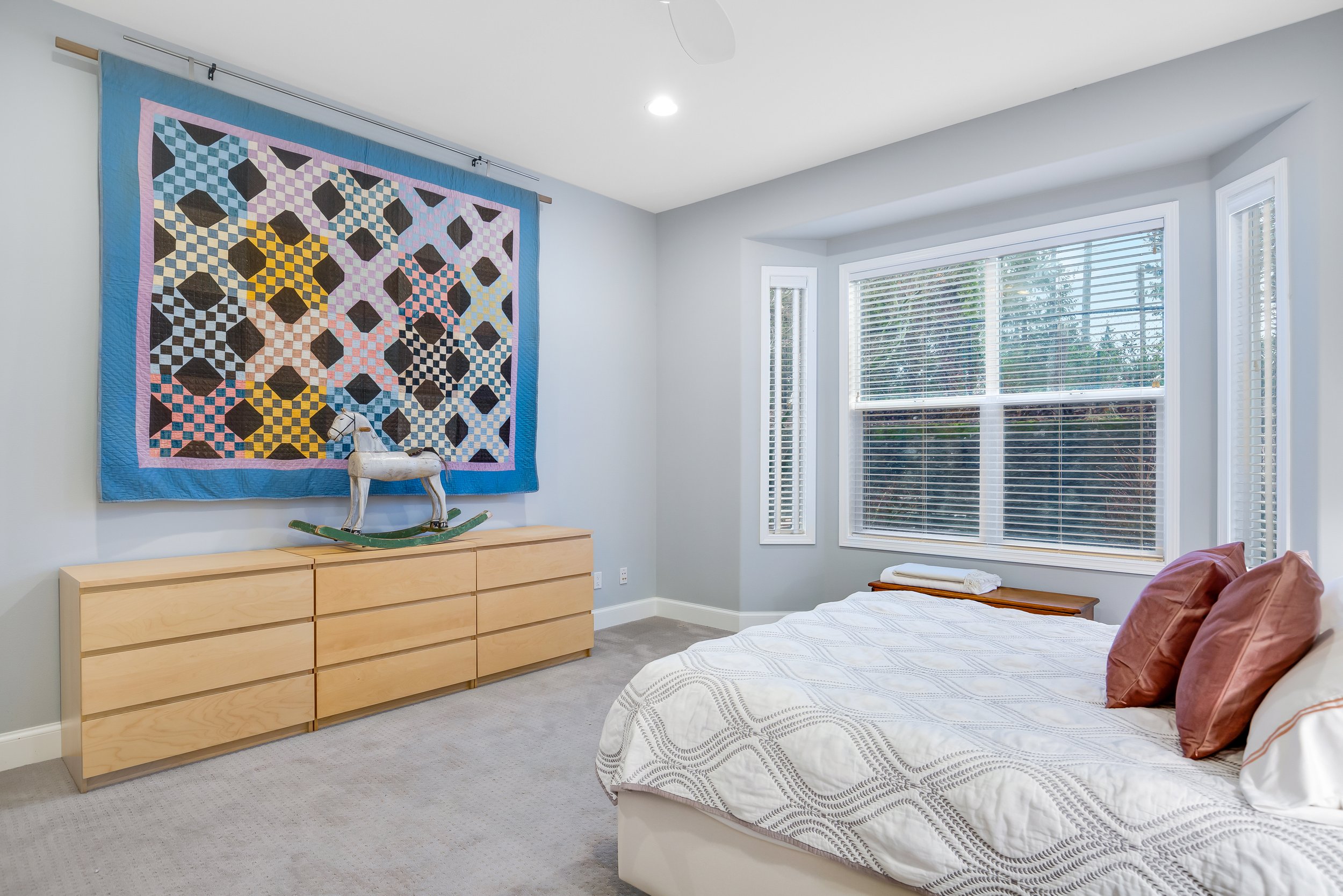  interior of second bedroom with carpet, large window, and king bed 