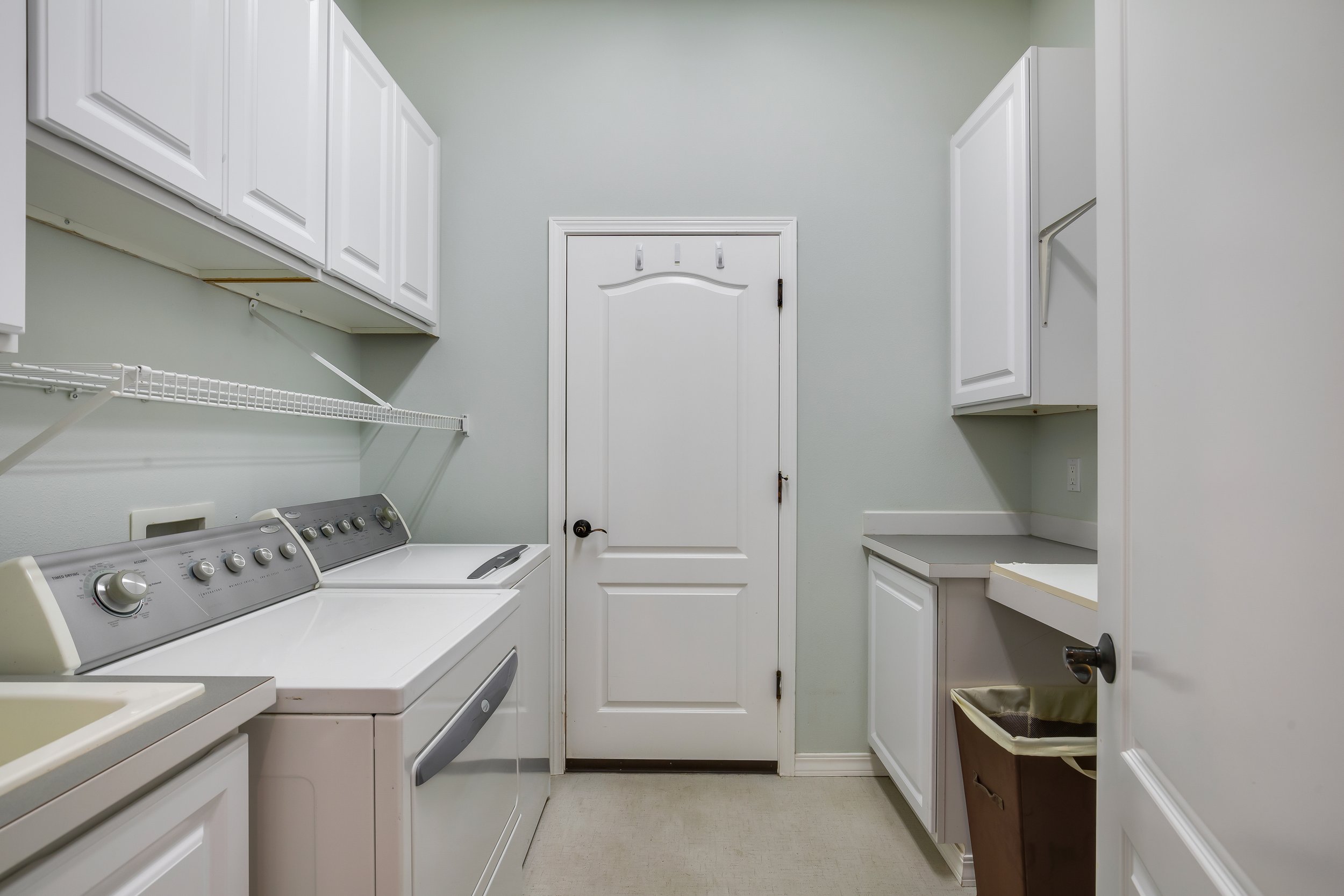  interior of laundry room with cabinets, washer and dryer 