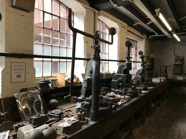 This room was full of workers using the fly presses to stamp and pierce small decorative items.
