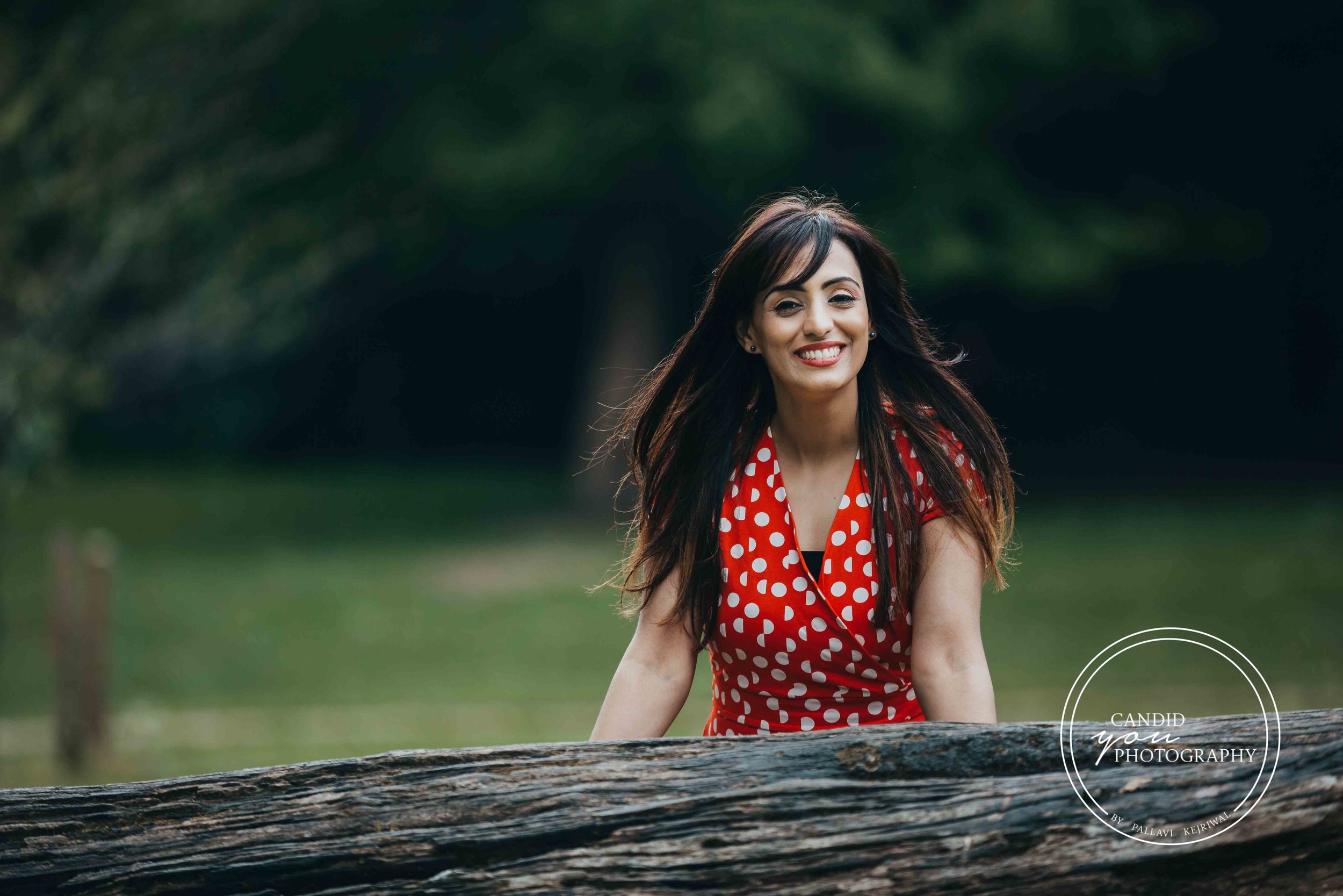 Beautiful lady smiling in orange polka dot dress in park
