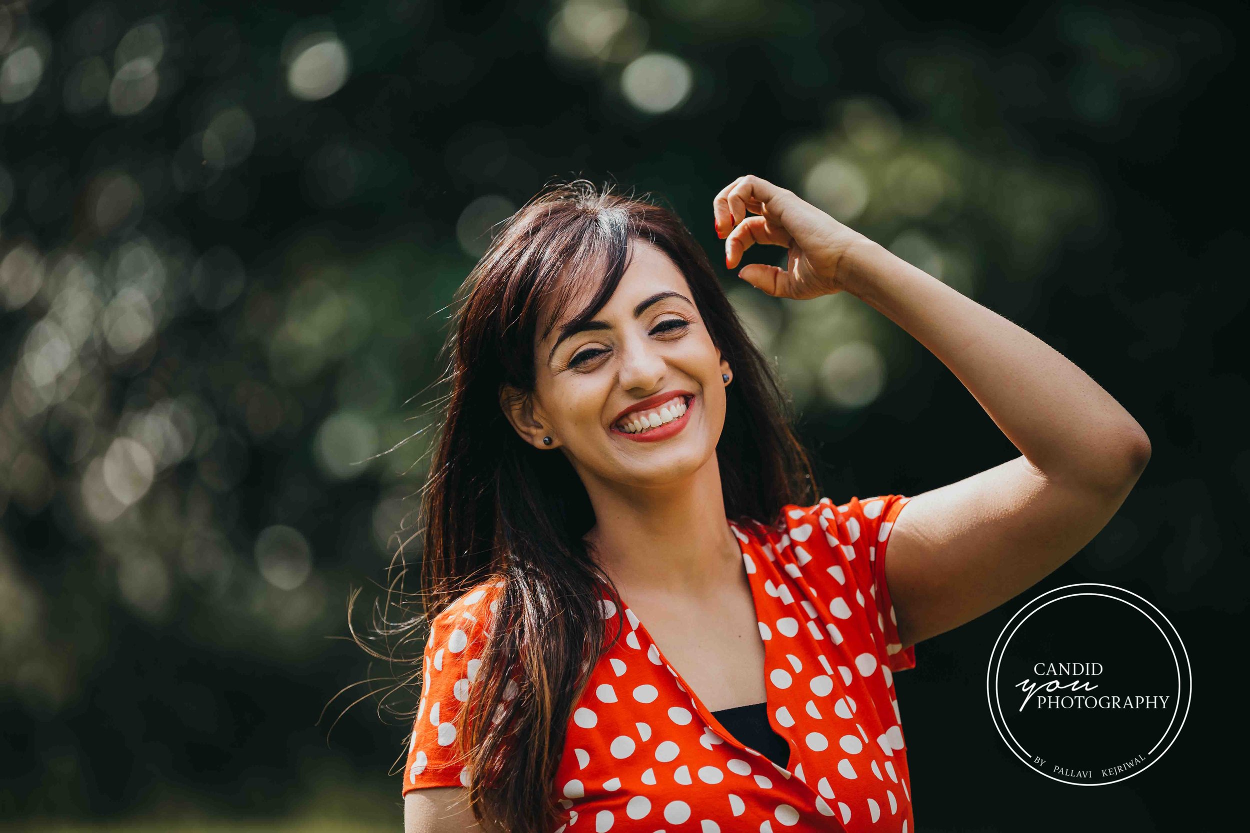 beautiful lady in orange polka dot dress flinging hair and smiling