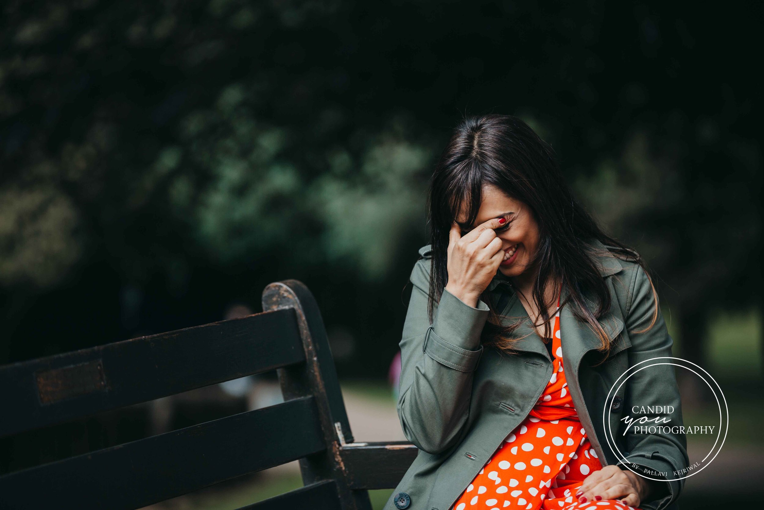 Beautiful lady laughing heartily in the park and embarassed