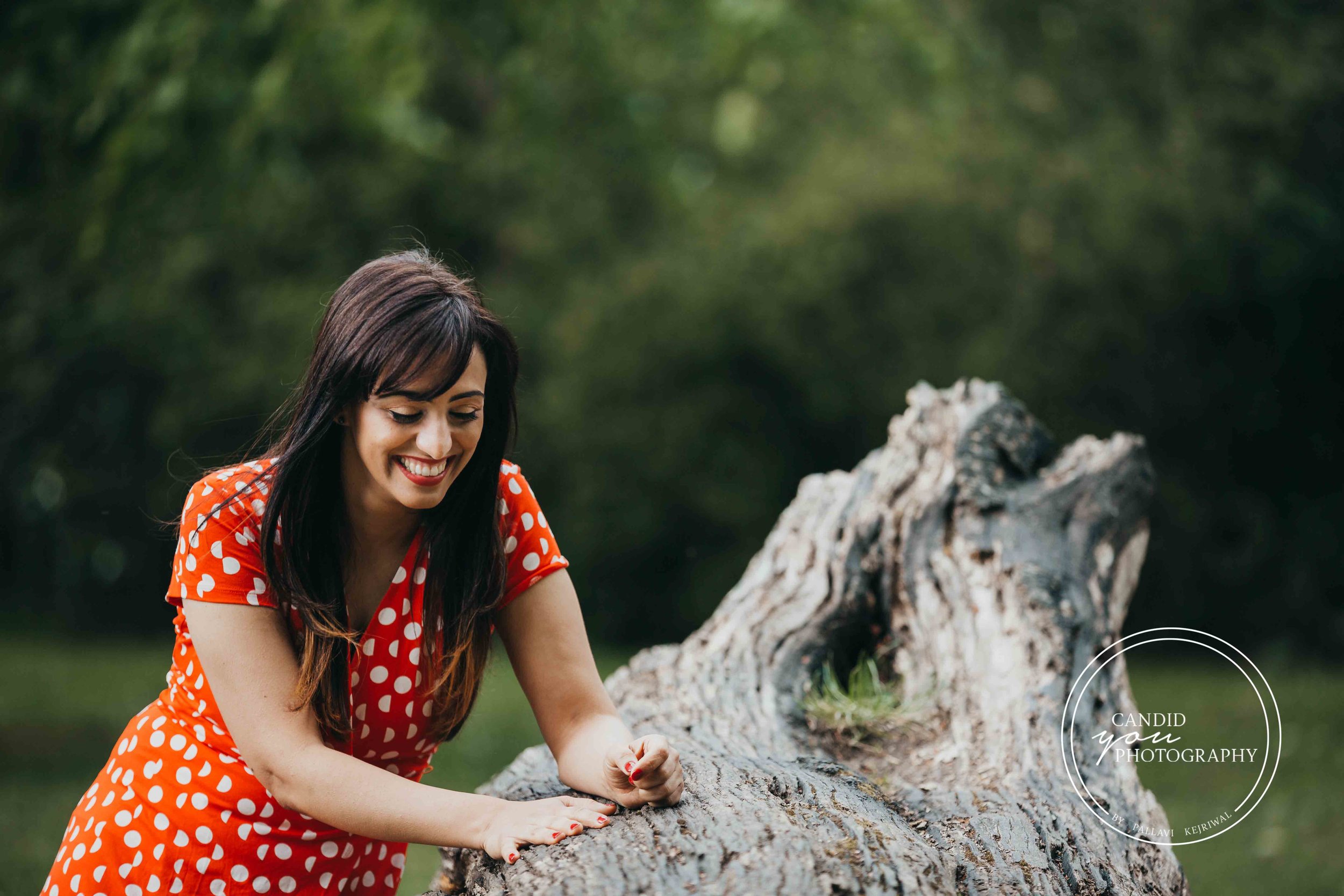 Beautiful woman in orange polka dot dress in park