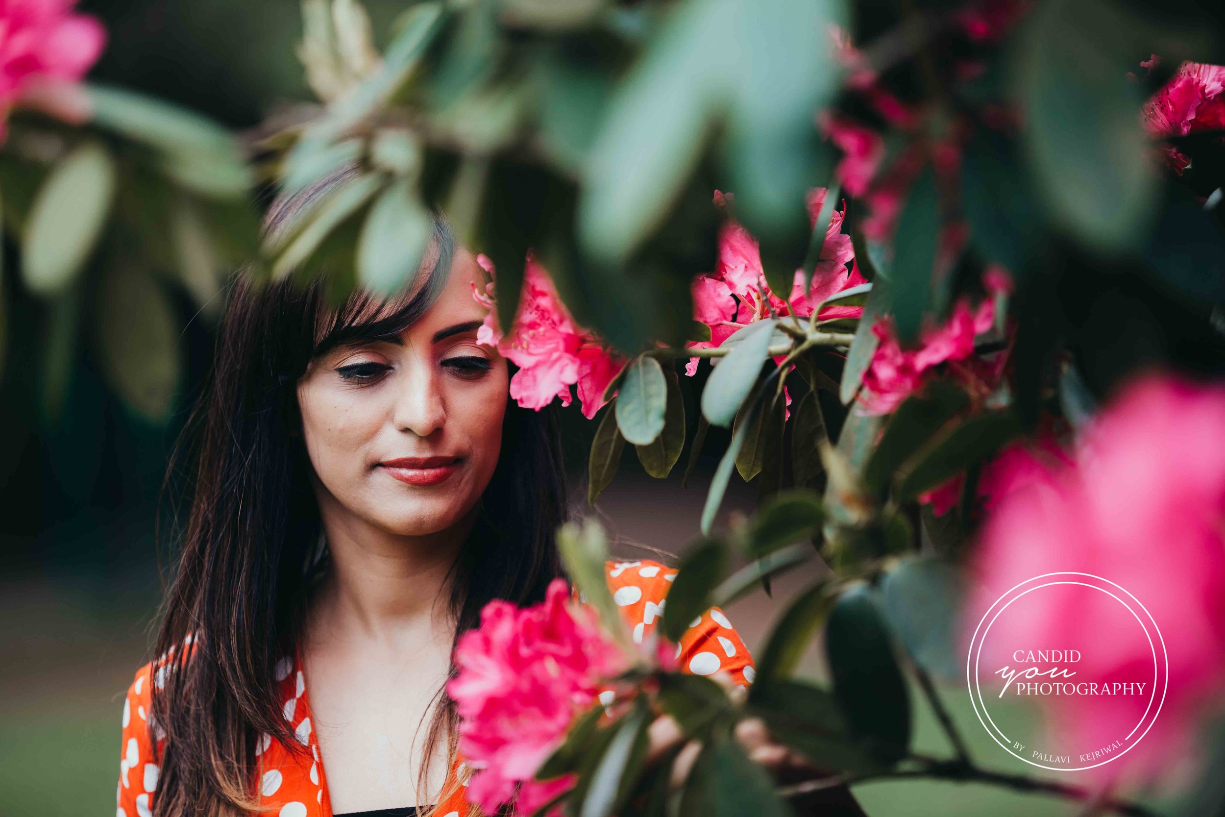 gorgeous woman looking at pink flowers