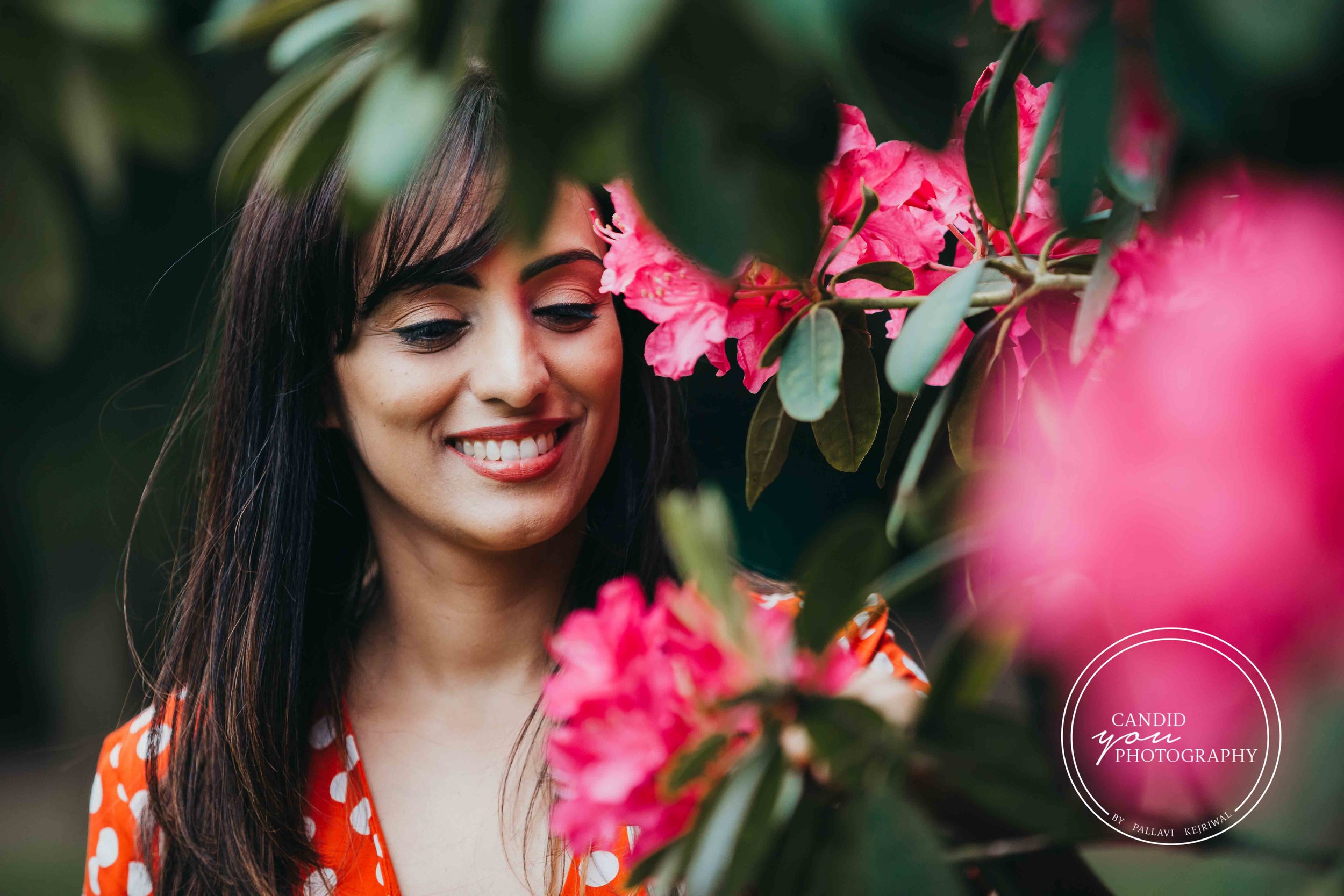 beautiful lady smiling at pink flowers