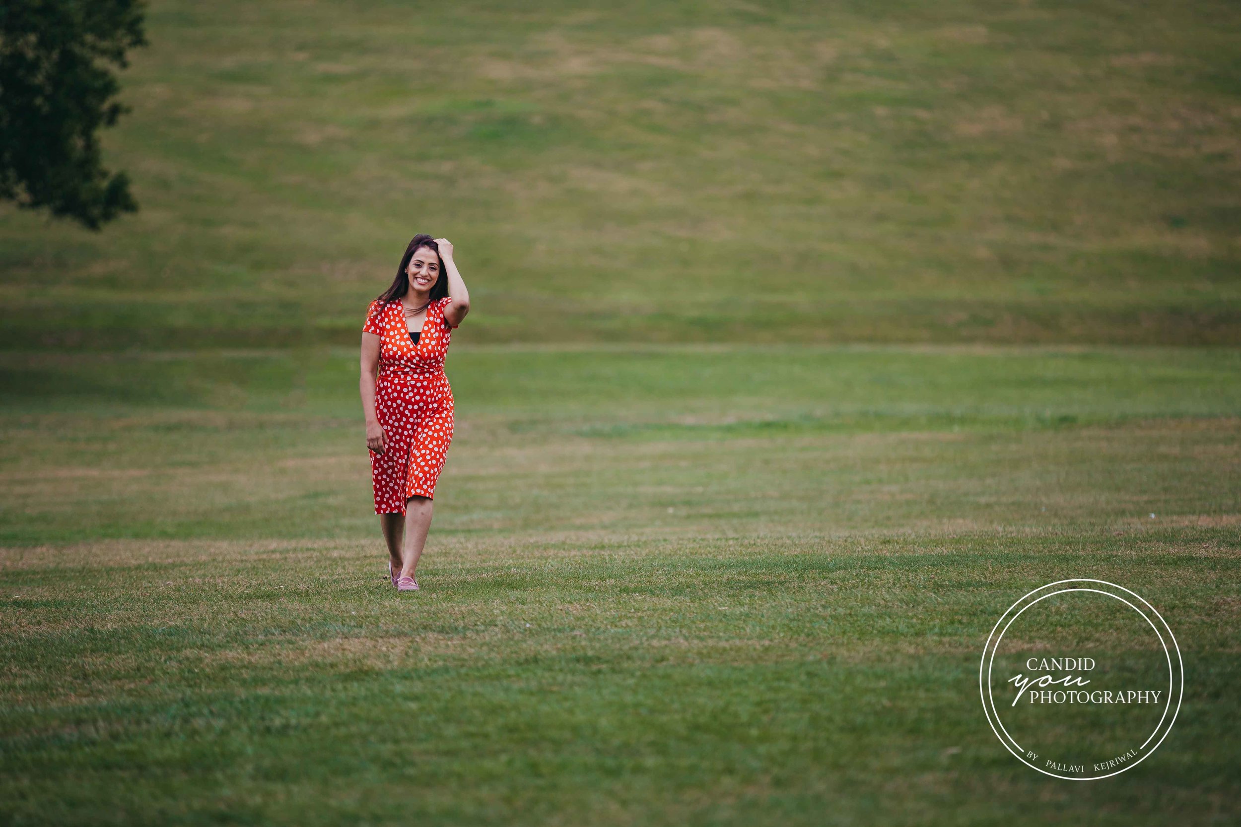 beautiful lady walking in park in orange polka dot dress