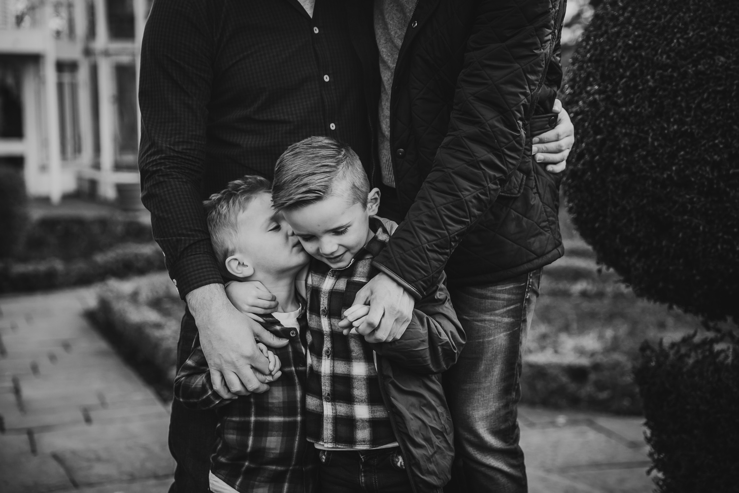 two brothers under 5s hugging and kissing each other in plaid shirts