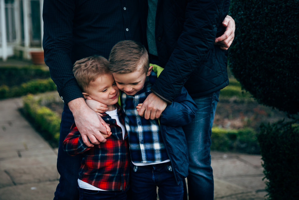 two brothers under 5s hugging and kissing each other in plaid shirts