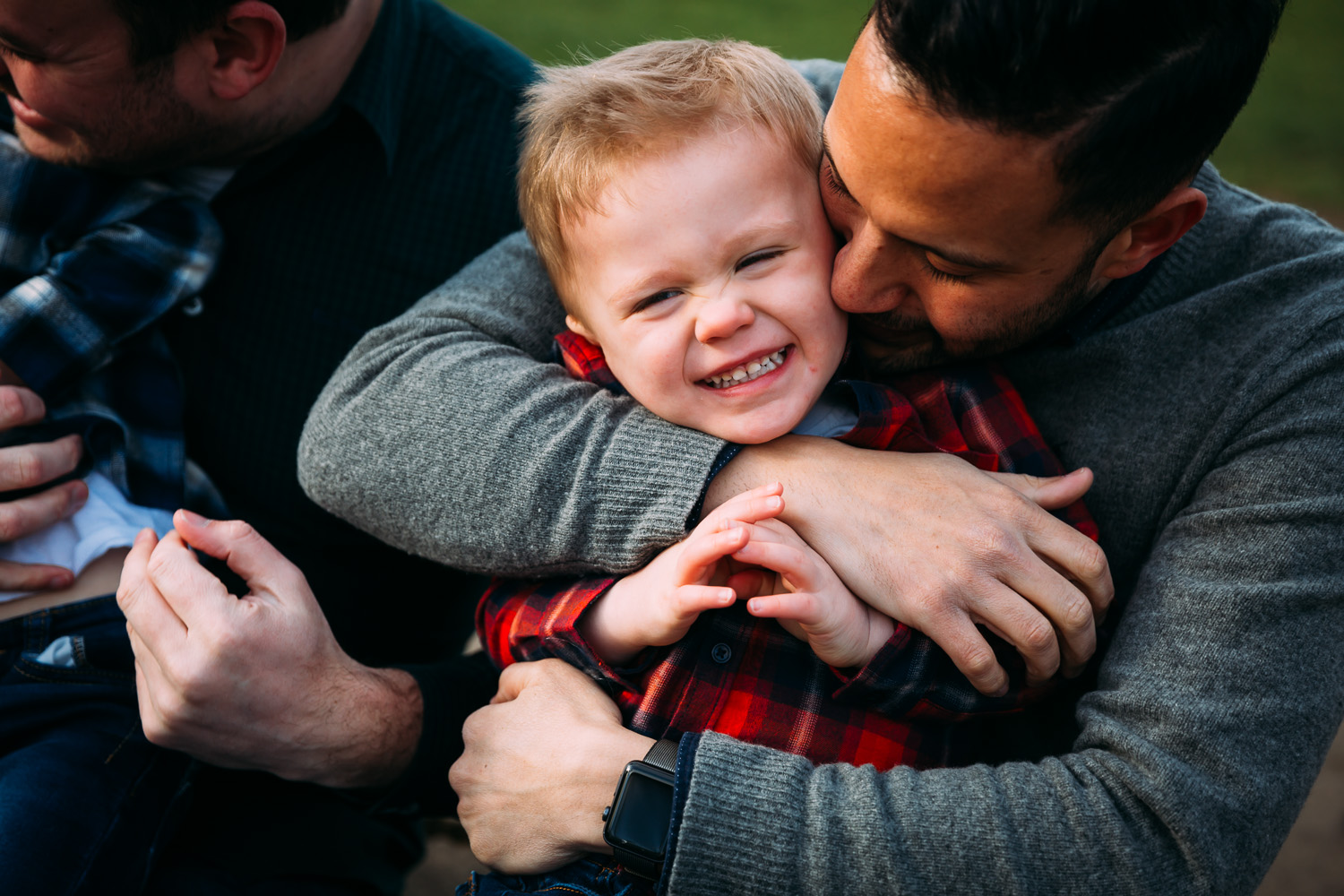 LGBTQ father deeply hugging adopted son