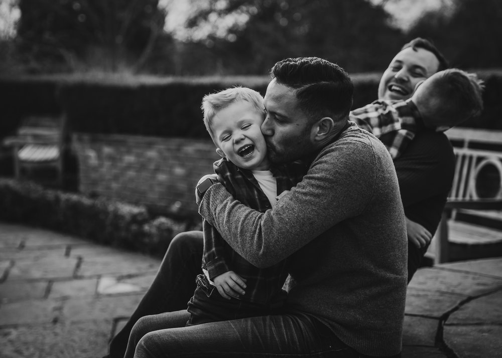 LGBTQ father deeply hugging adopted son