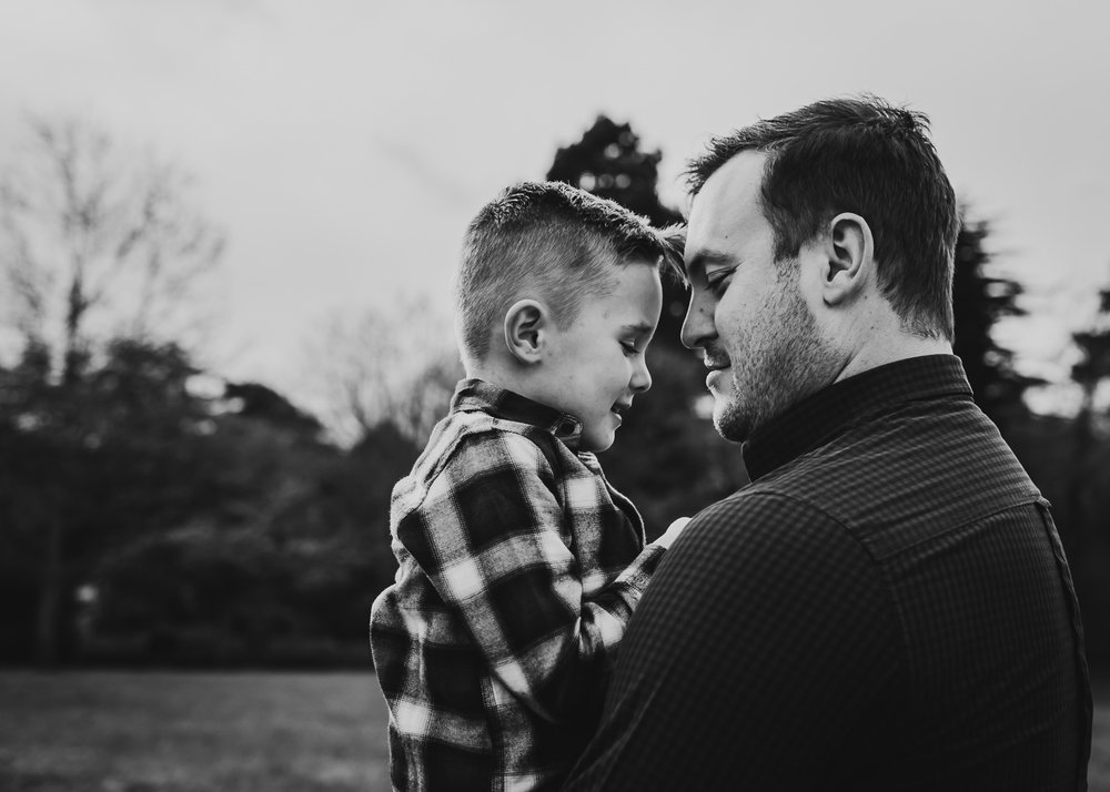 LGBTQ father deeply hugging adopted son