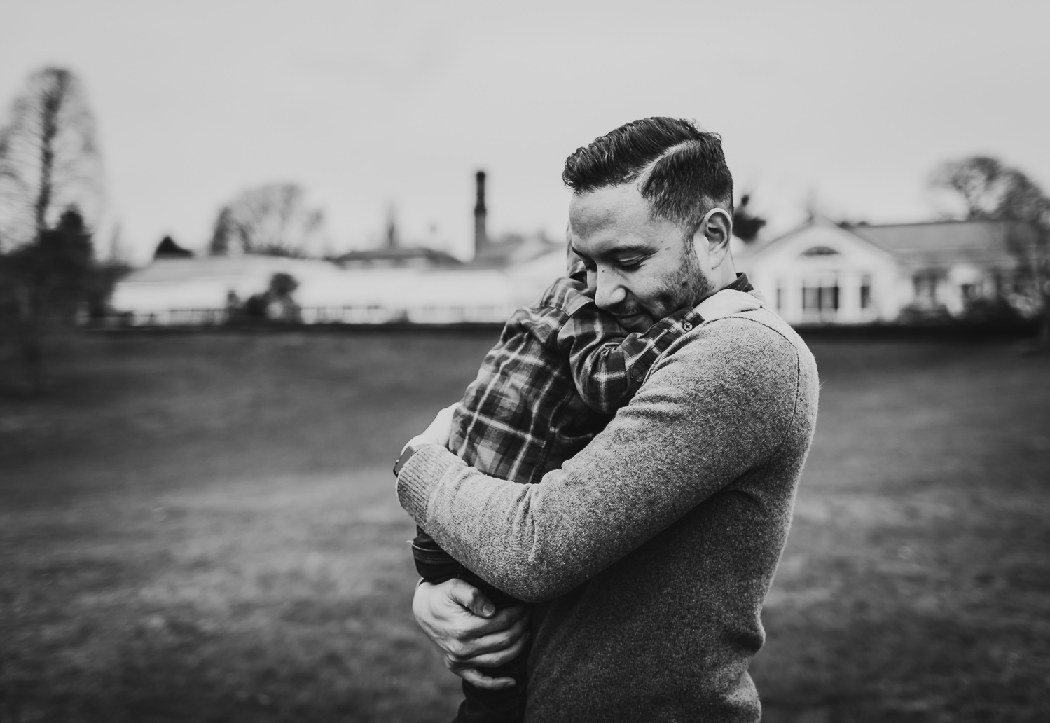 LGBTQ father deeply hugging adopted son