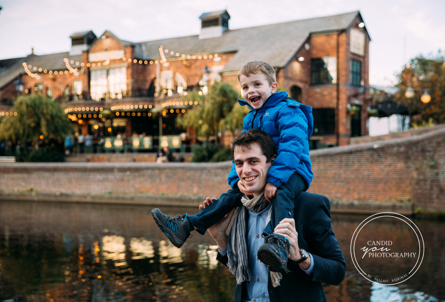 Boy sitting on Dad's shoulders next to Birmingham Canals in Brindley Place