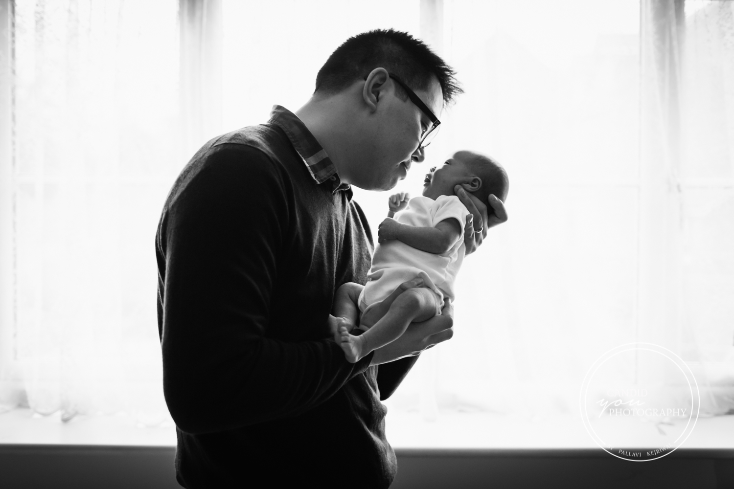 New Dad looks lovingly at newborn daughter