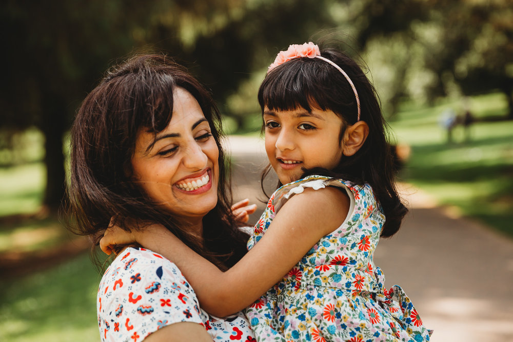 mum smiling and laughing with daughter in park