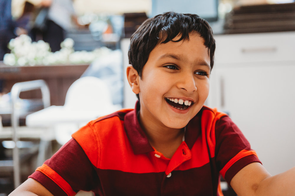 boy laughing in orange tshirt