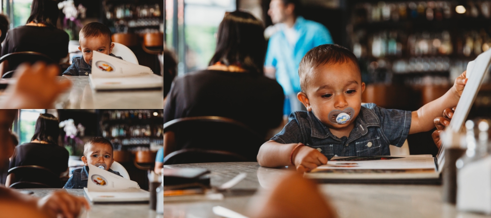 one year old boy looking through menu in cafe