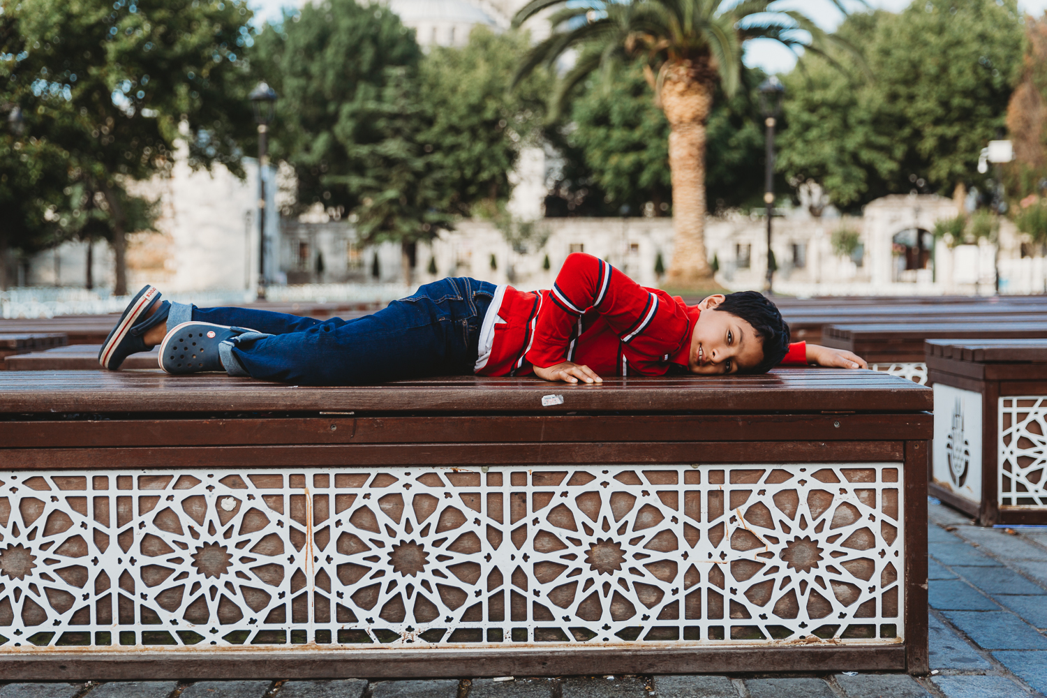 boy lying down on beautiful bench