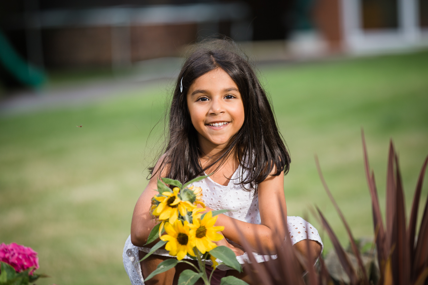 5 year old girl enjoying in her garden during in home family photo session
