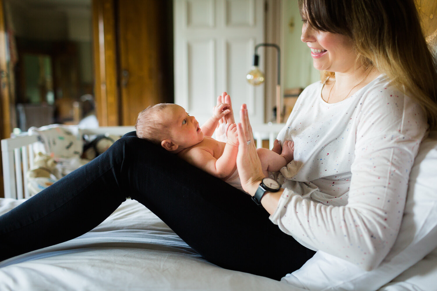 Mum playing with newborn baby at home